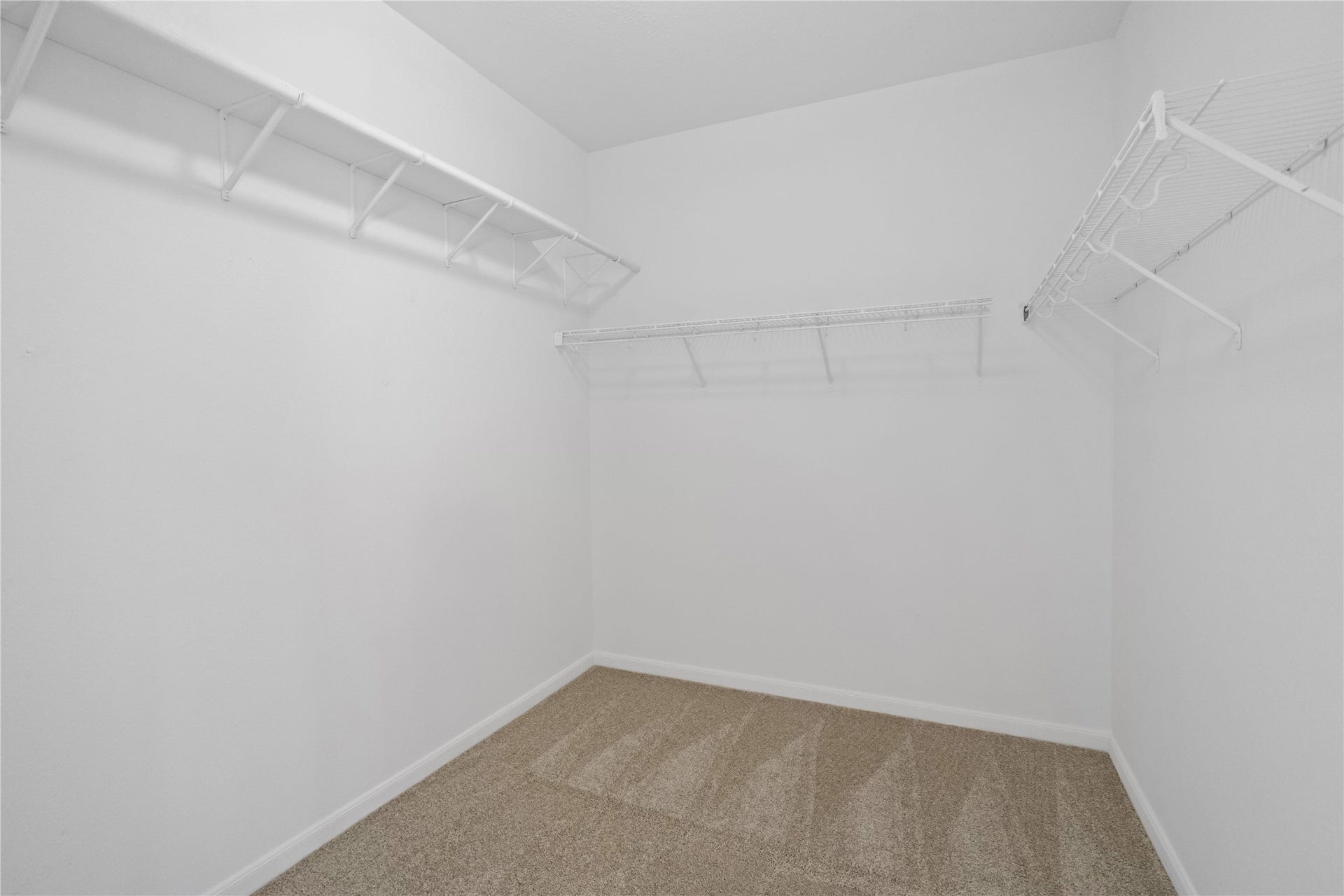 21611 Manitou Falls Lane, Katy, TX 77449 Walk-In Closet Spacious walk-in closet with wraparound hanging and shelf storage plus carpeted flooring.