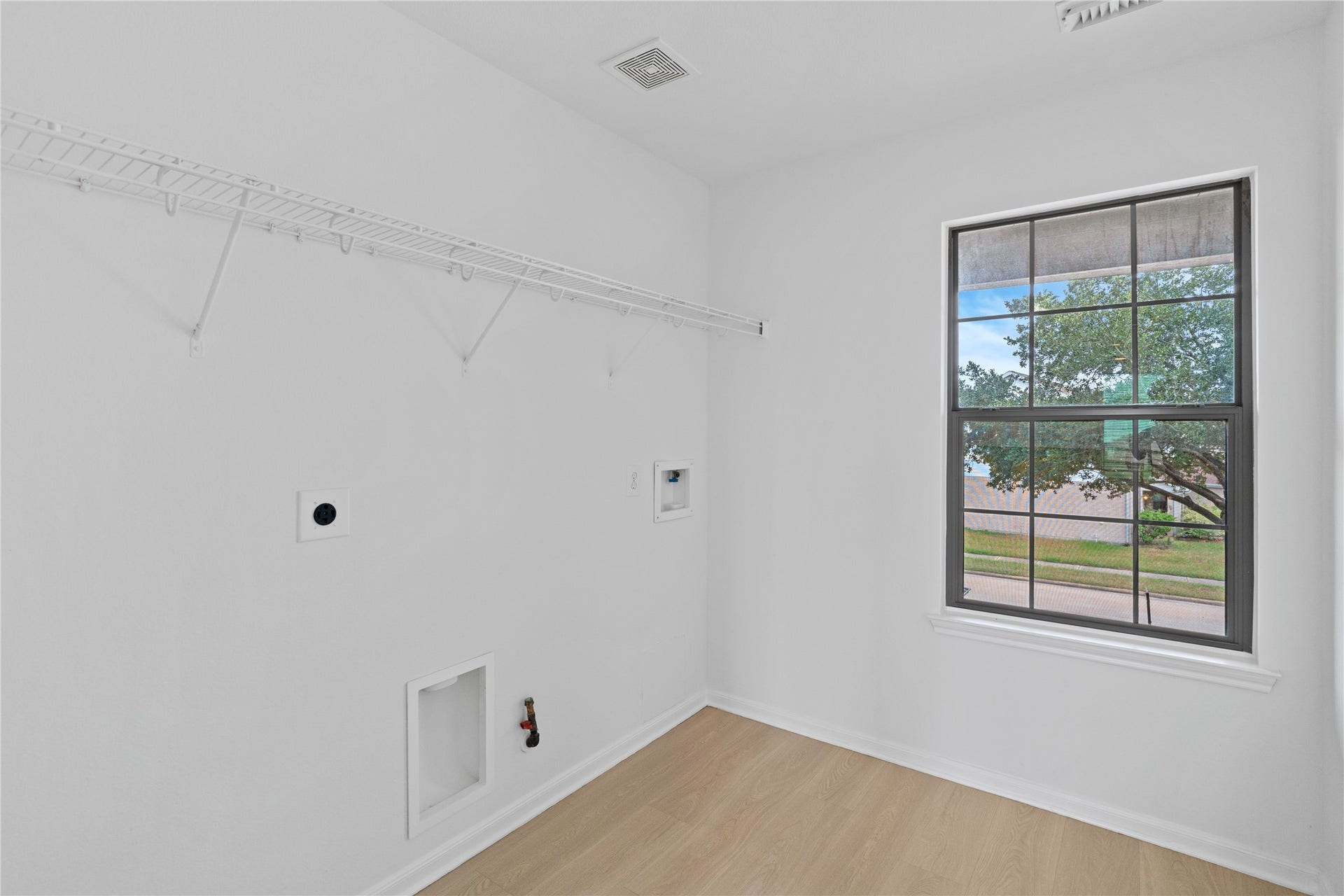 21611 Manitou Falls Lane, Katy, TX 77449 Laundry Room Dedicated laundry space with washer and dryer connections, built-in wire shelving, a window for natural light, and easy-care flooring.