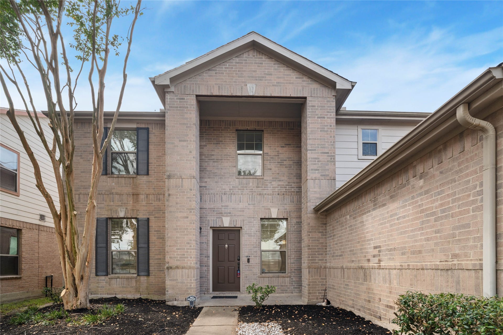 21611 Manitou Falls Lane, Katy, TX 77449 Front Entry Closer view of the two-story brick faade showcases the recessed covered entrance, architectural brick detailing, and landscaped walkway.