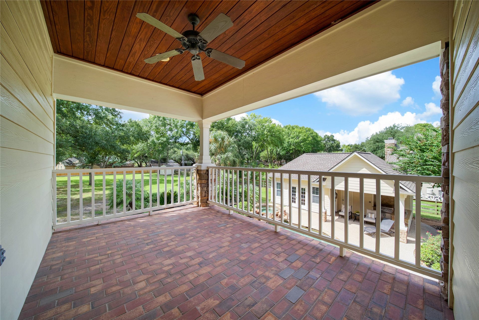 12635 Hunters Canyon Lane, Cypress, TX 77429 The charming covered balcony with a ceiling fan overlooks a lush backyard, perfect for relaxing and entertaining. The brick flooring and tongue and groove ceiling continue in this outdoor space.