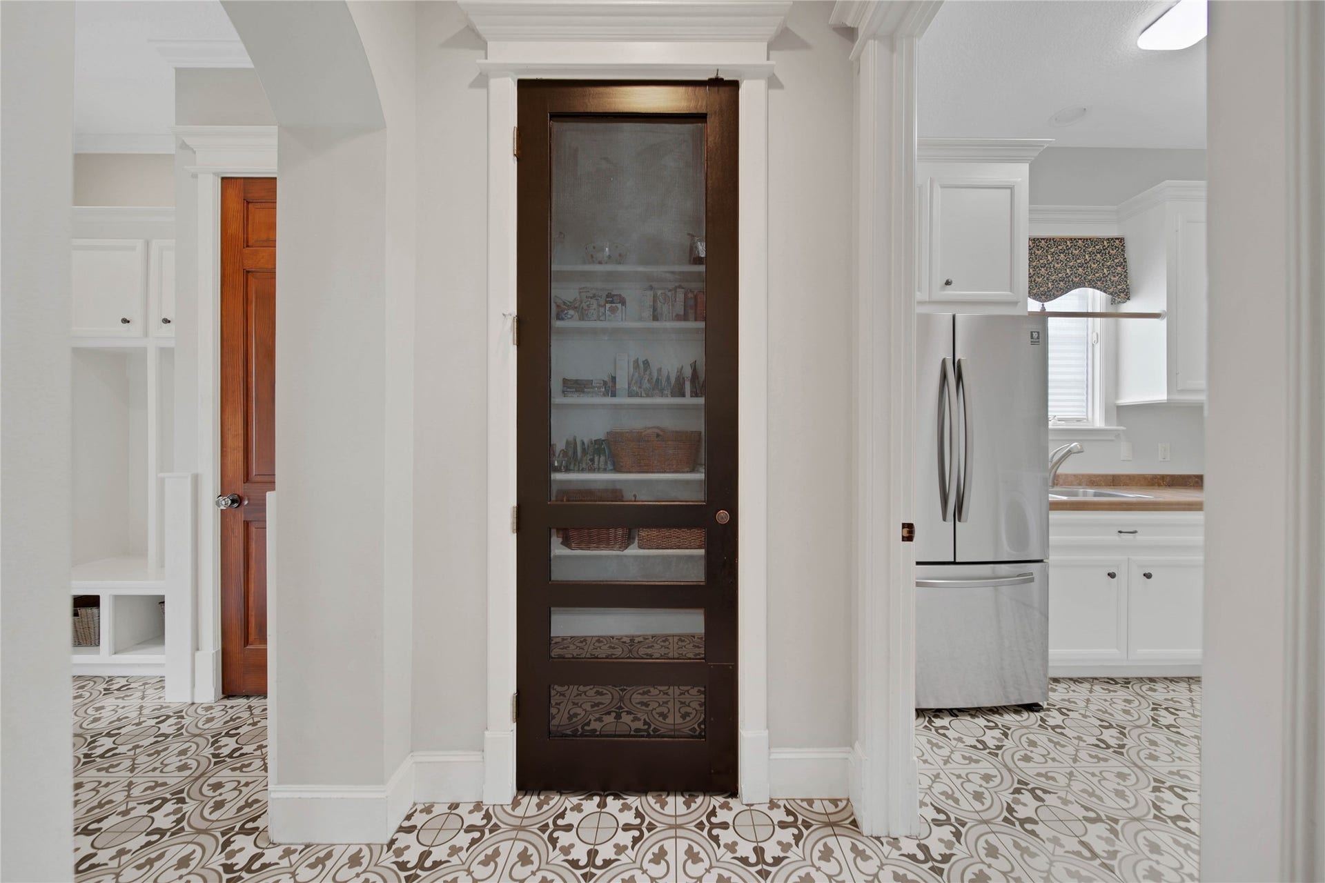 12635 Hunters Canyon Lane, Cypress, TX 77429 Convenient in the hallway off the kitchen is this walk-in pantry and the screen door detailing complements the upgraded patterned tile floor, leading into laundry room and mud room.