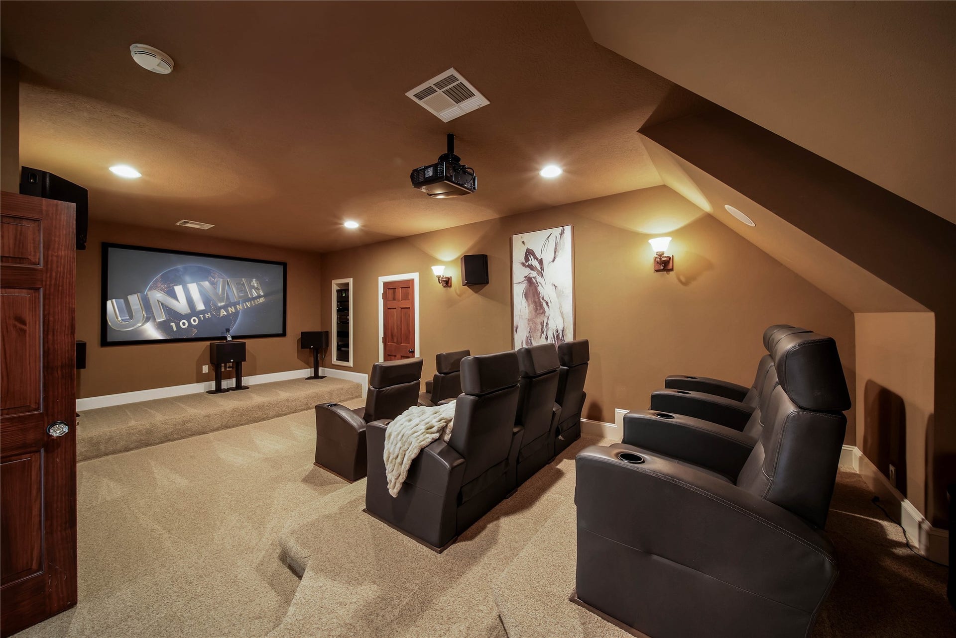 12635 Hunters Canyon Lane, Cypress, TX 77429 Experience cinematic luxury in this home theater featuring stadium seating, a large screen, and surround sound system, all set in a cozy, carpeted room.