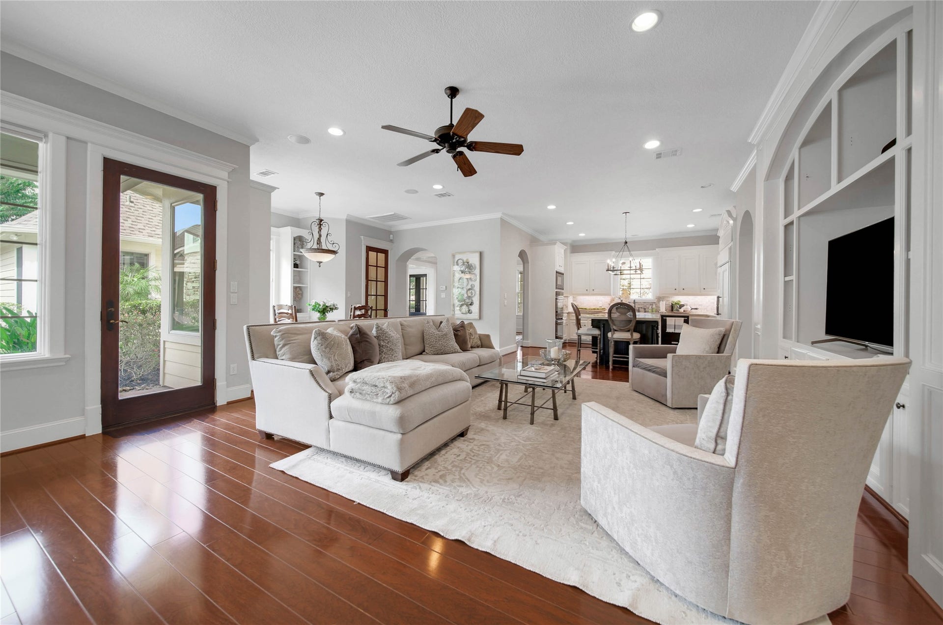 12635 Hunters Canyon Lane, Cypress, TX 77429 The open-concept living area with elegant hardwood floors, cozy seating, and abundant natural light, seamlessly connects to the kitchen and breakfast area. The French door leads to one of the covered patios and pool area.