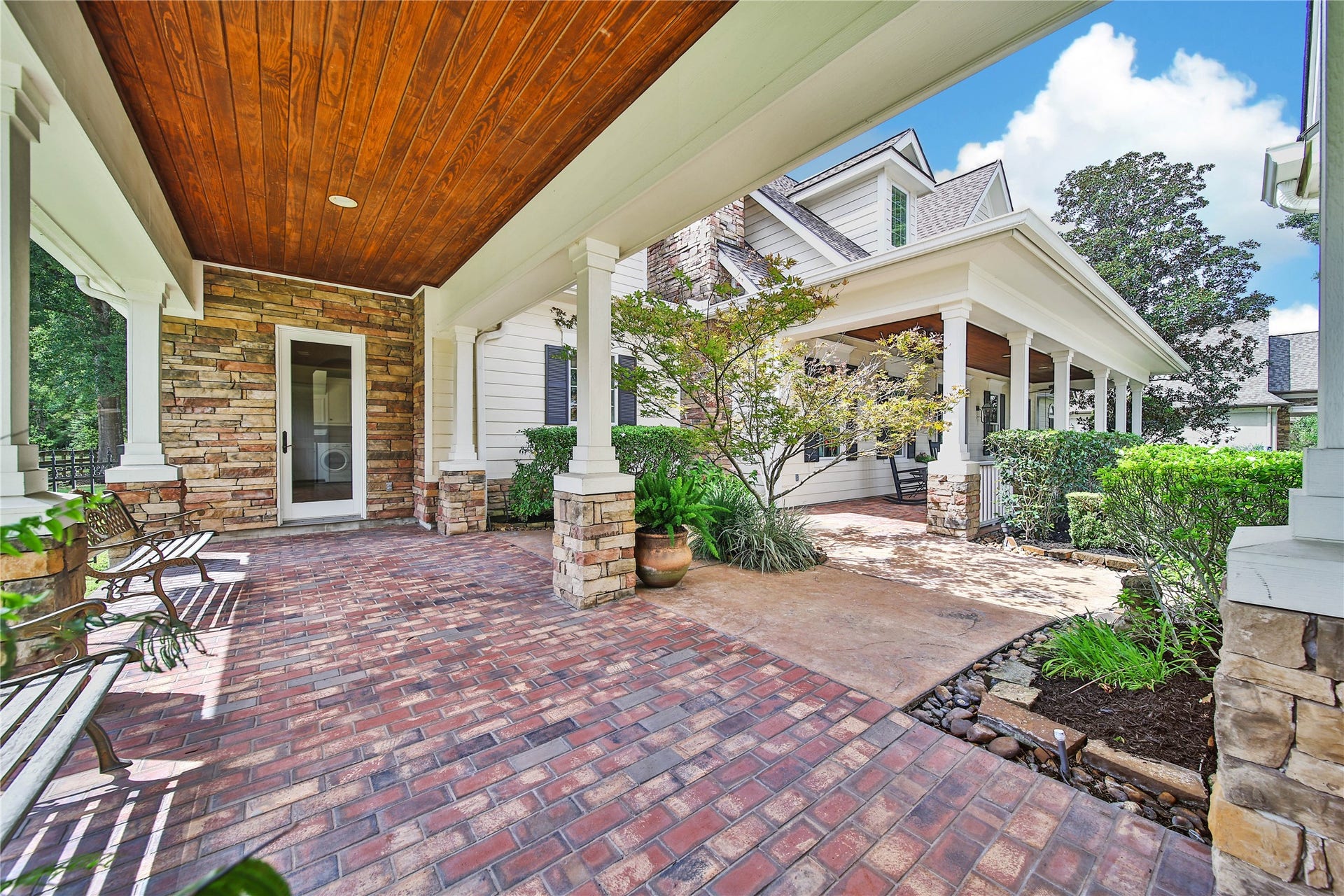 12635 Hunters Canyon Lane, Cypress, TX 77429 The classic brick flooring and tongue and groove ceiling continue in this wide breezeway that connects the home to the garage. There is a small courtyard with stamped concrete surrounded by lush landscaping.