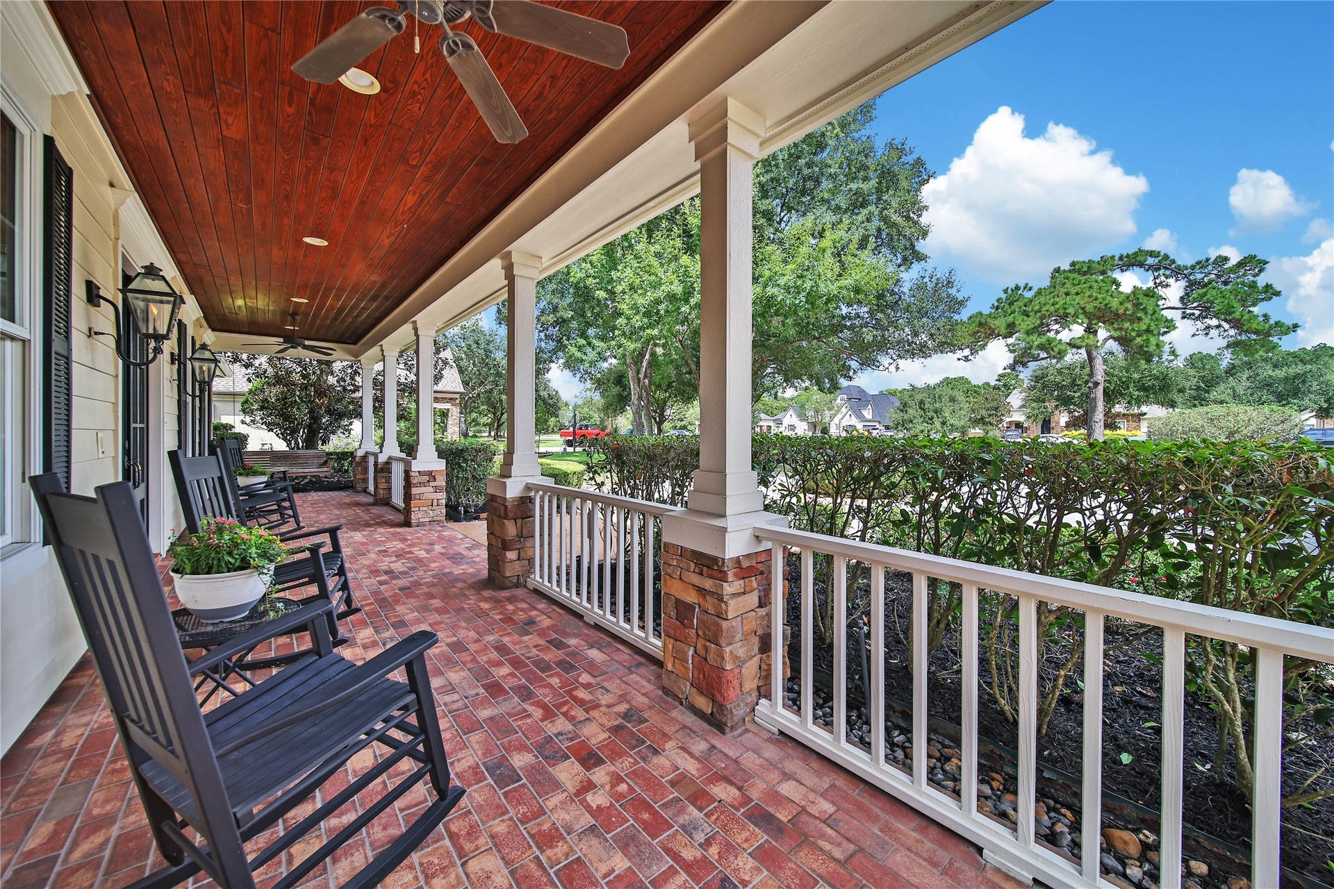 12635 Hunters Canyon Lane, Cypress, TX 77429 The charming front porch with stacked stone columns, brick flooring, and the rich wood tongue and groove ceiling is perfect for relaxing and enjoying the peaceful neighborhood views. The double French doors are flanked by gas lanterns adding to the Southern Charm.