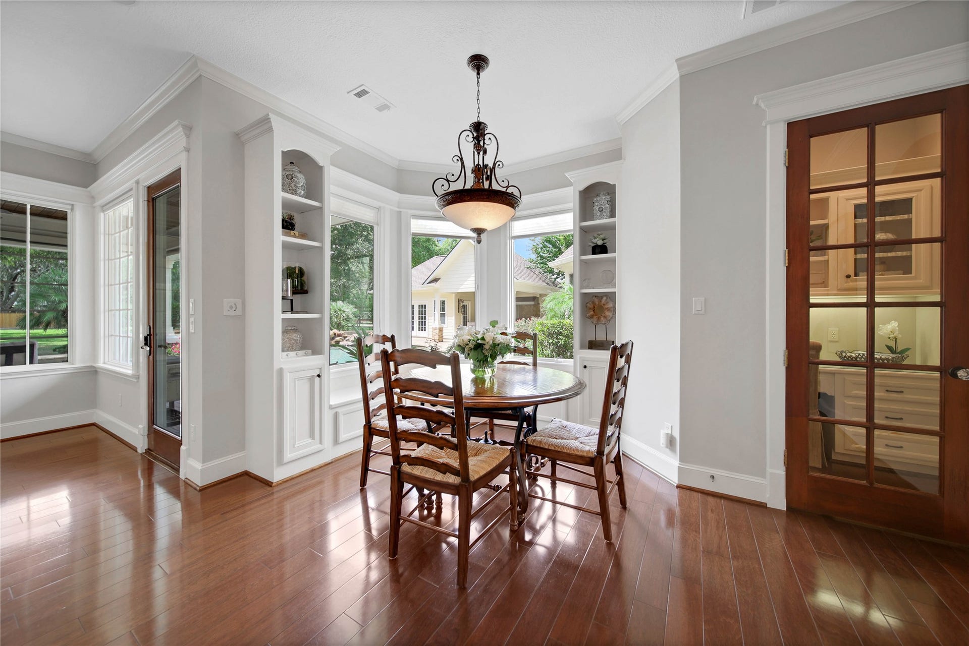 12635 Hunters Canyon Lane, Cypress, TX 77429 The bright and inviting breakfast nook with elegant wood flooring, an arched wall of windows, and built-in shelving and window seat, is perfect for enjoying morning meals with a view.