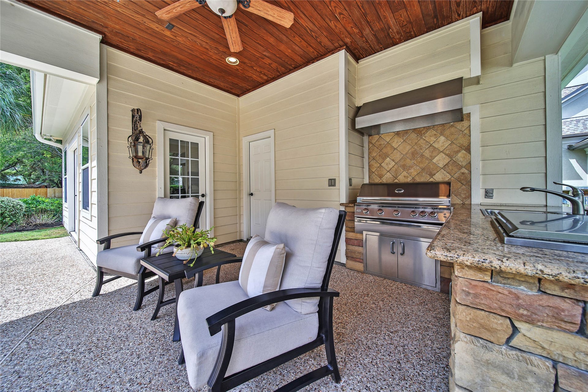 12635 Hunters Canyon Lane, Cypress, TX 77429 Experience outdoor living with this inviting patio featuring comfortable seating, a built-in grill, and a ceiling fan, perfect for entertaining. The summer kitchen is stacked stone with a granite counter top, wet sink, and built-in cooler. There is access to the full bath in the pool house.