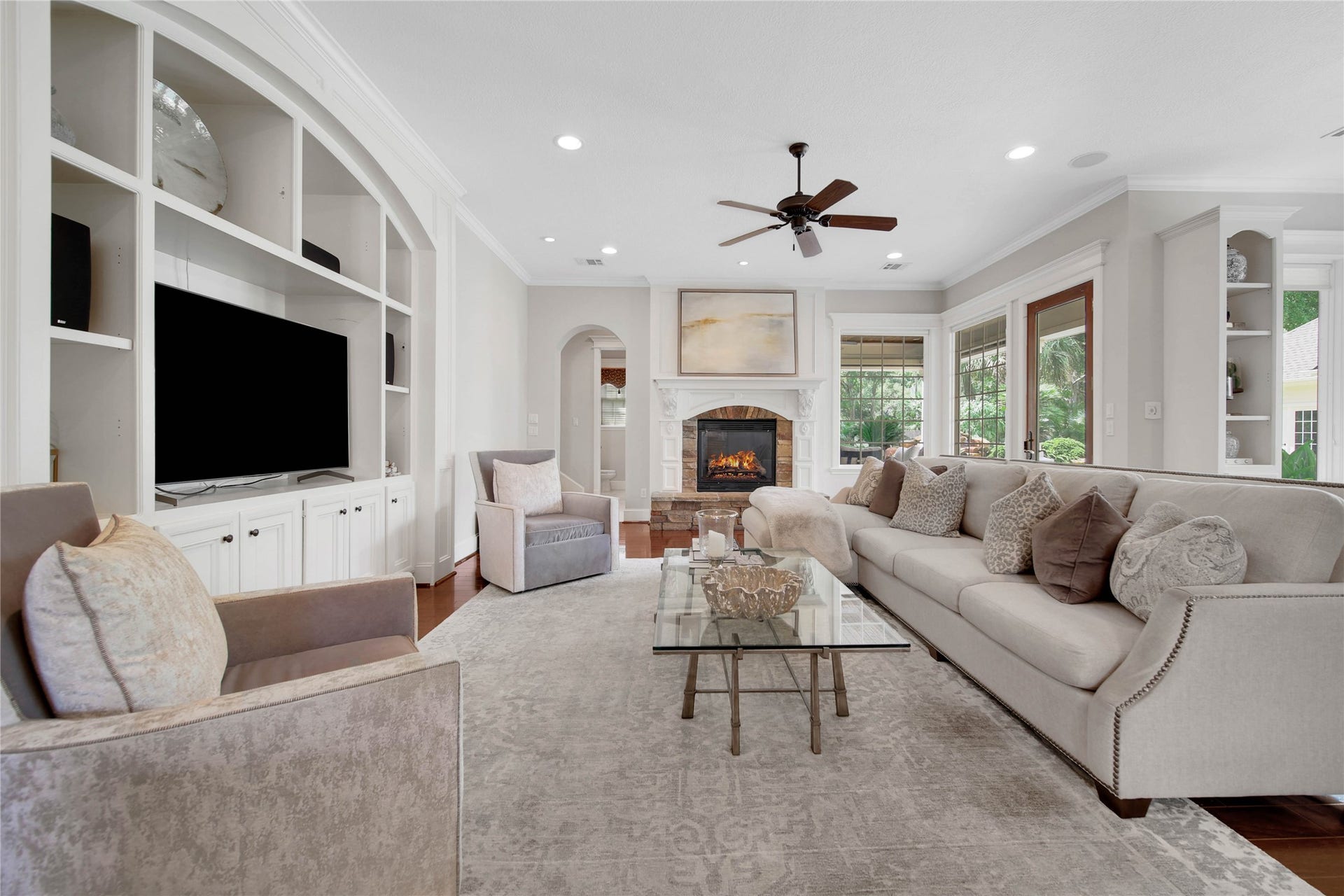 12635 Hunters Canyon Lane, Cypress, TX 77429 The spacious family room featuring a built-in entertainment center, a cozy gas log fireplace, and ample natural light from large windows, is perfect for relaxation and entertaining.