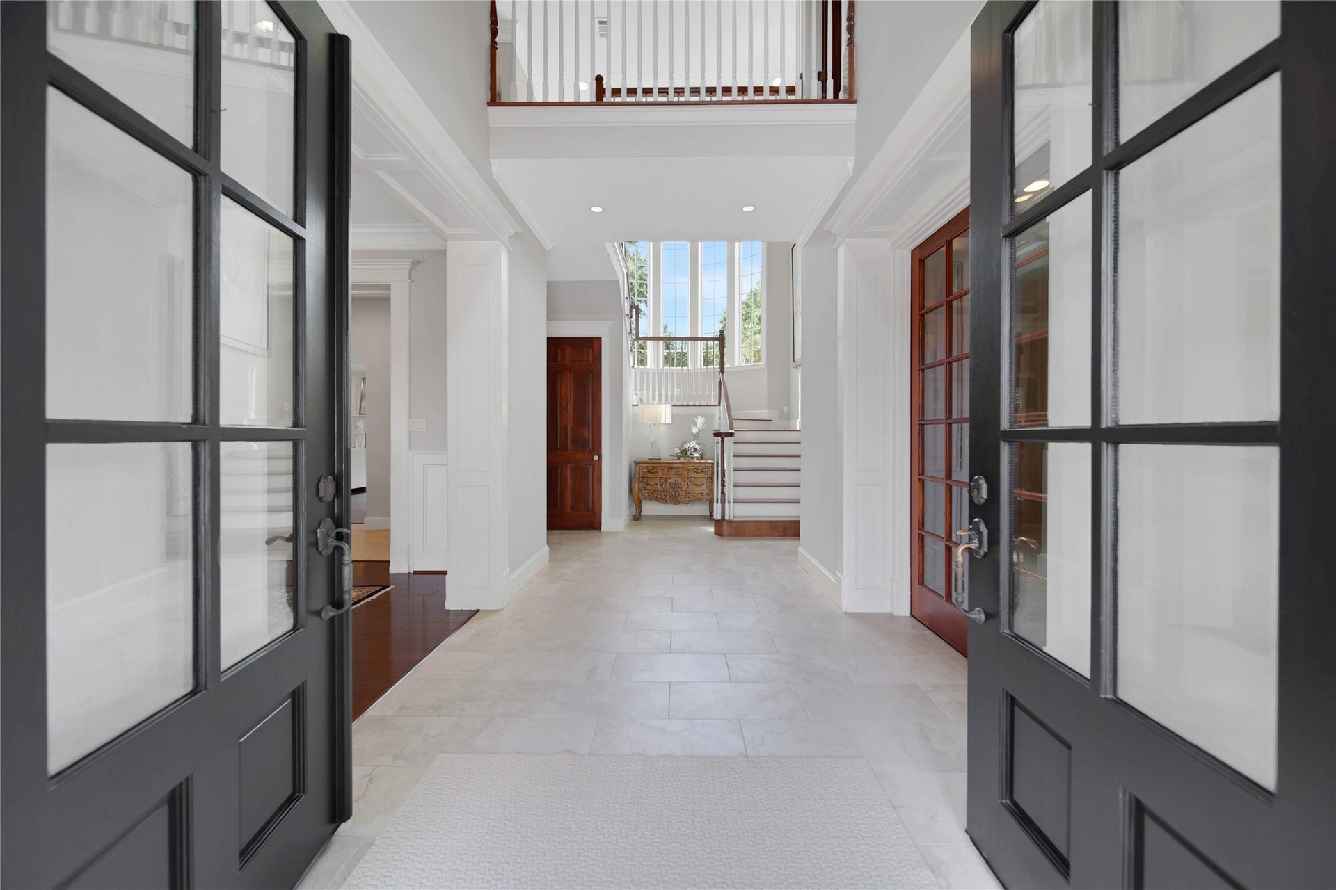 12635 Hunters Canyon Lane, Cypress, TX 77429 Welcome to the entrance with elegant double doors, high ceilings, and a view of the staircase leading to the upper level, offering a grand first impression.