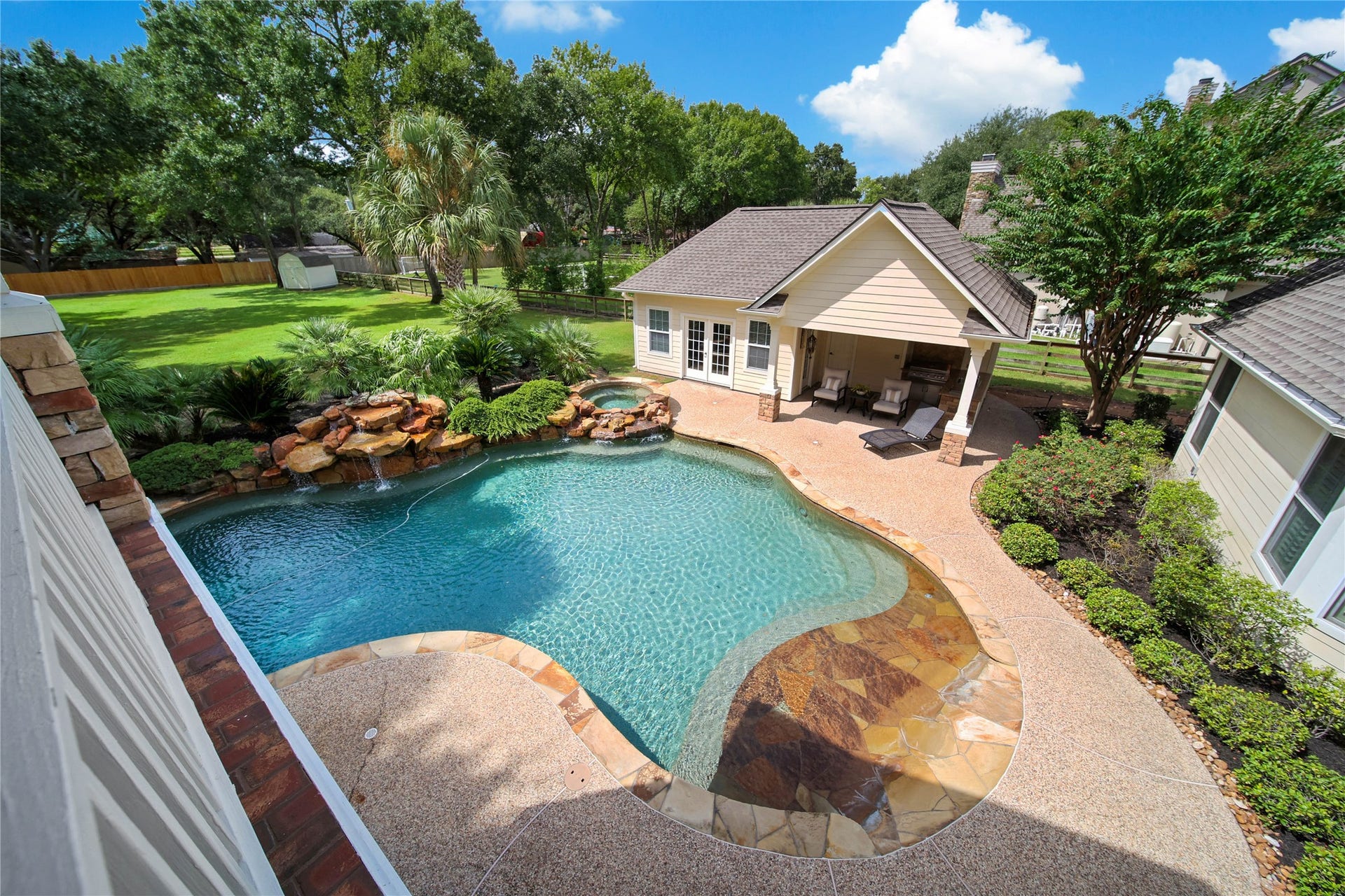12635 Hunters Canyon Lane, Cypress, TX 77429 Enjoy the luxury of a beautifully landscaped backyard featuring a stunning pool with rock waterfall accents, two spacious patios for relaxation, and lush greenery for privacy and tranquility.