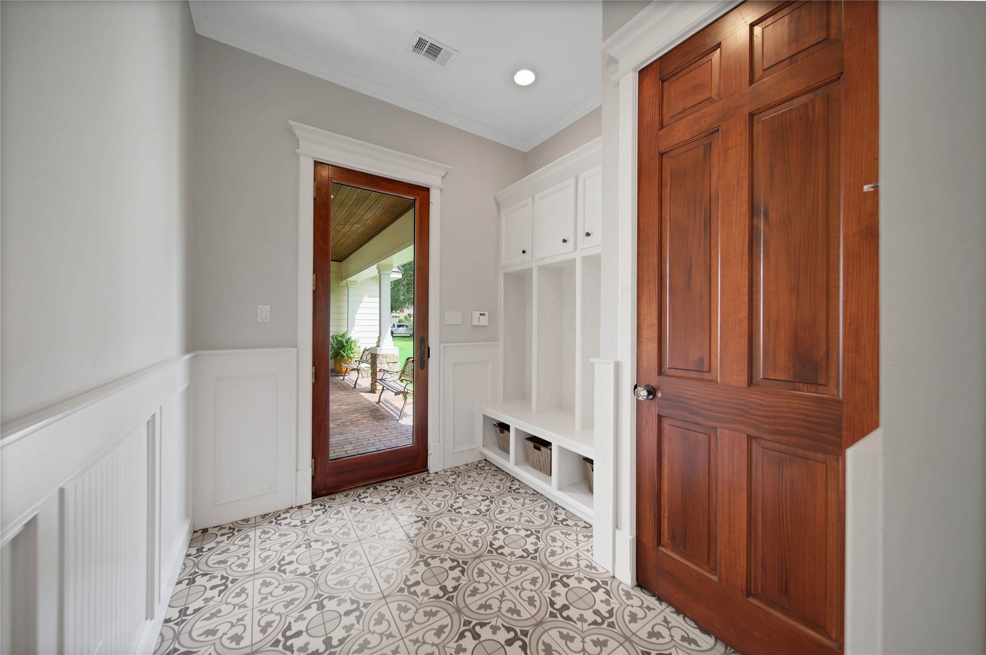 12635 Hunters Canyon Lane, Cypress, TX 77429 The drop zone and mud room has built-in storage cubbies, overhead cabinets and hooks for organization. There is a large utility closet and the French door opens to the brick floor breezeway connected to the three-car garage.