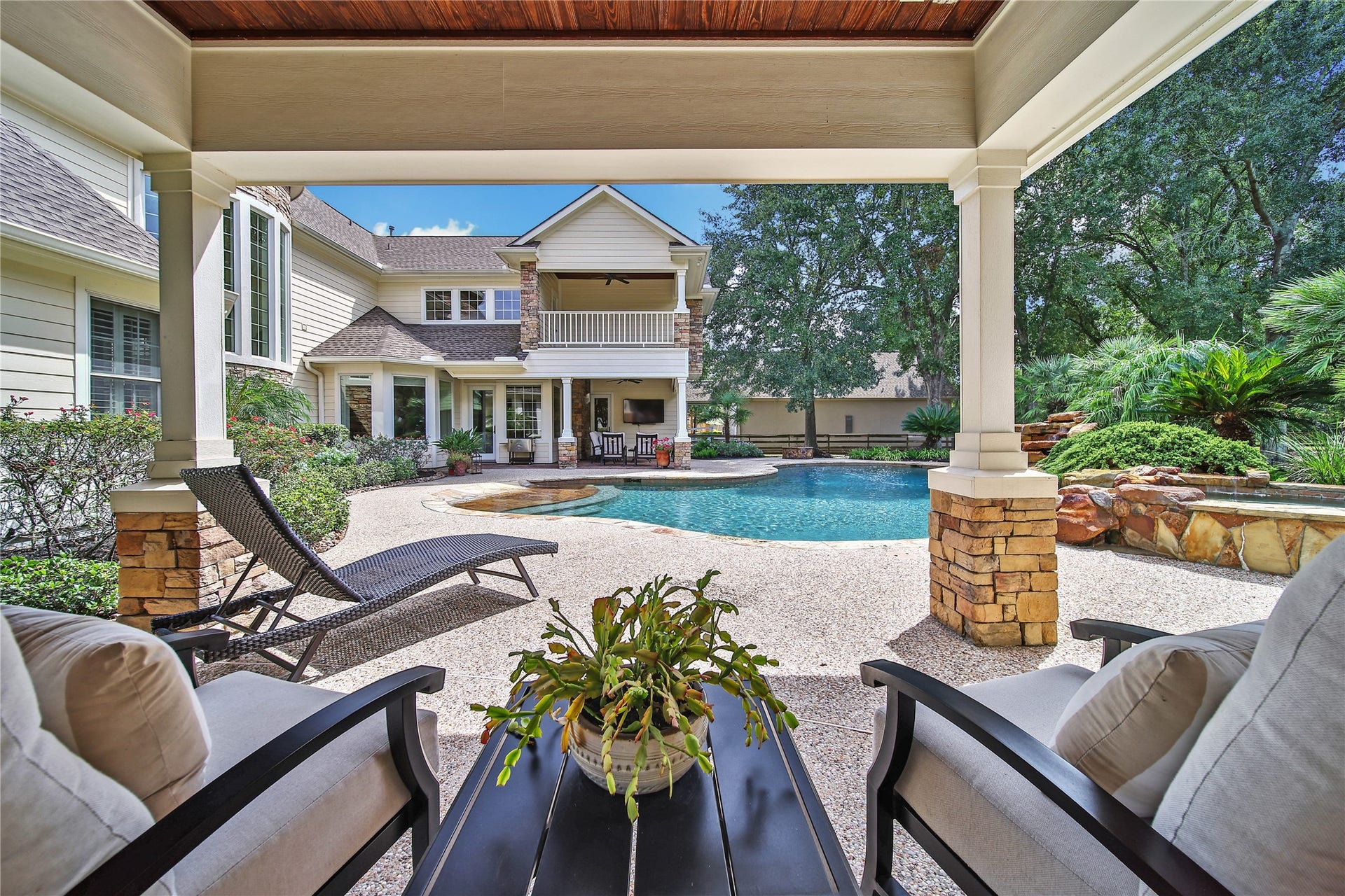 12635 Hunters Canyon Lane, Cypress, TX 77429 Luxurious outdoor oasis featuring a sparkling pool, the second spacious patio with cozy seating, and lush landscaping, perfect for relaxation and entertaining.