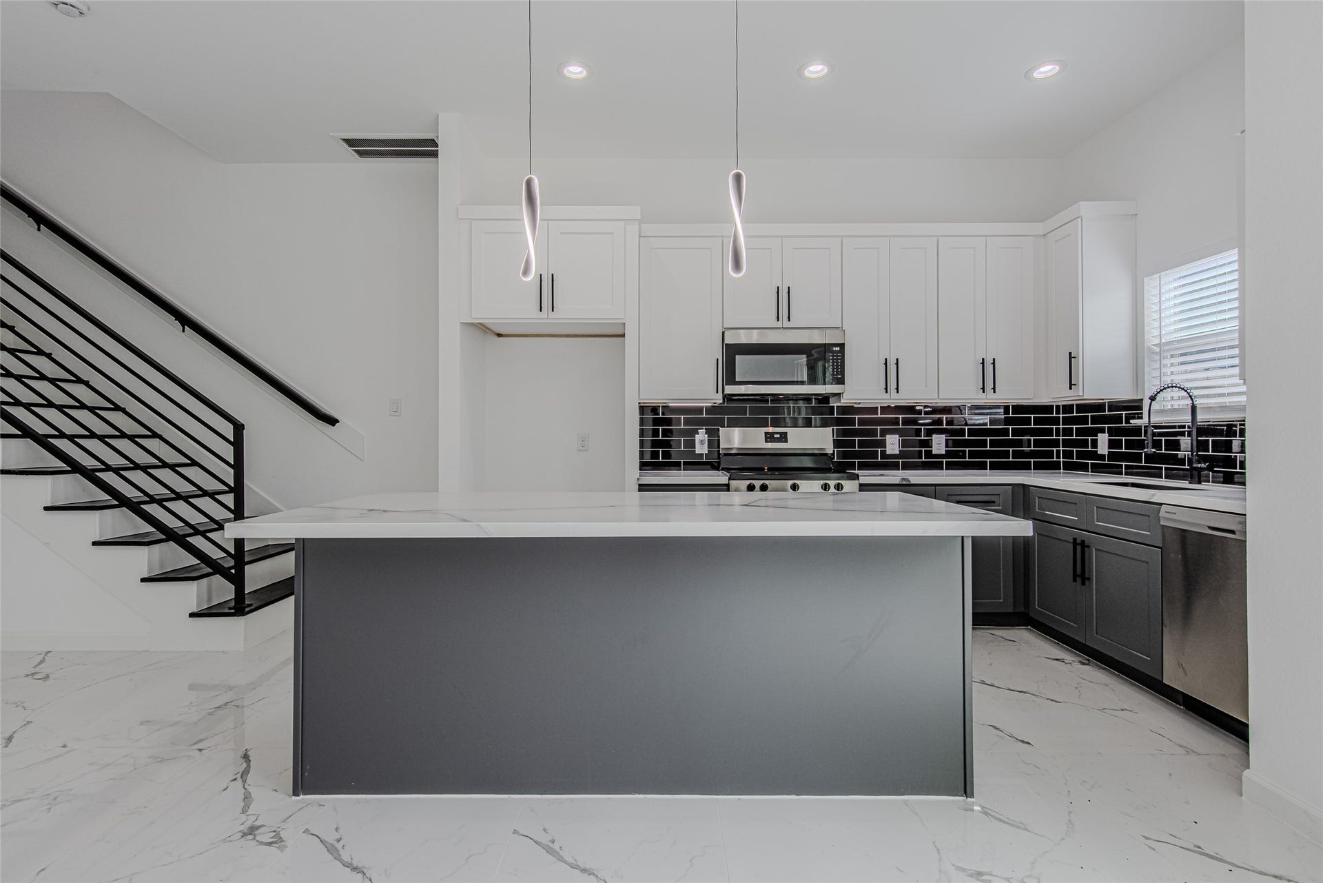 Modern kitchen with a large island, pendant lighting, ample cabinetry, and an open-concept layout perfect for everyday living and entertaining.