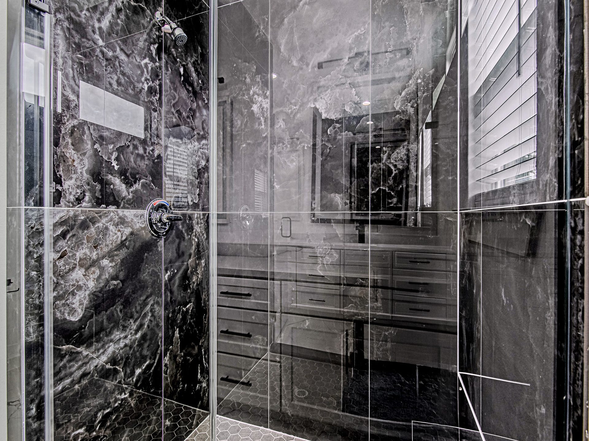 Walk-in shower with floor-to-ceiling tile and sleek modern finishes.