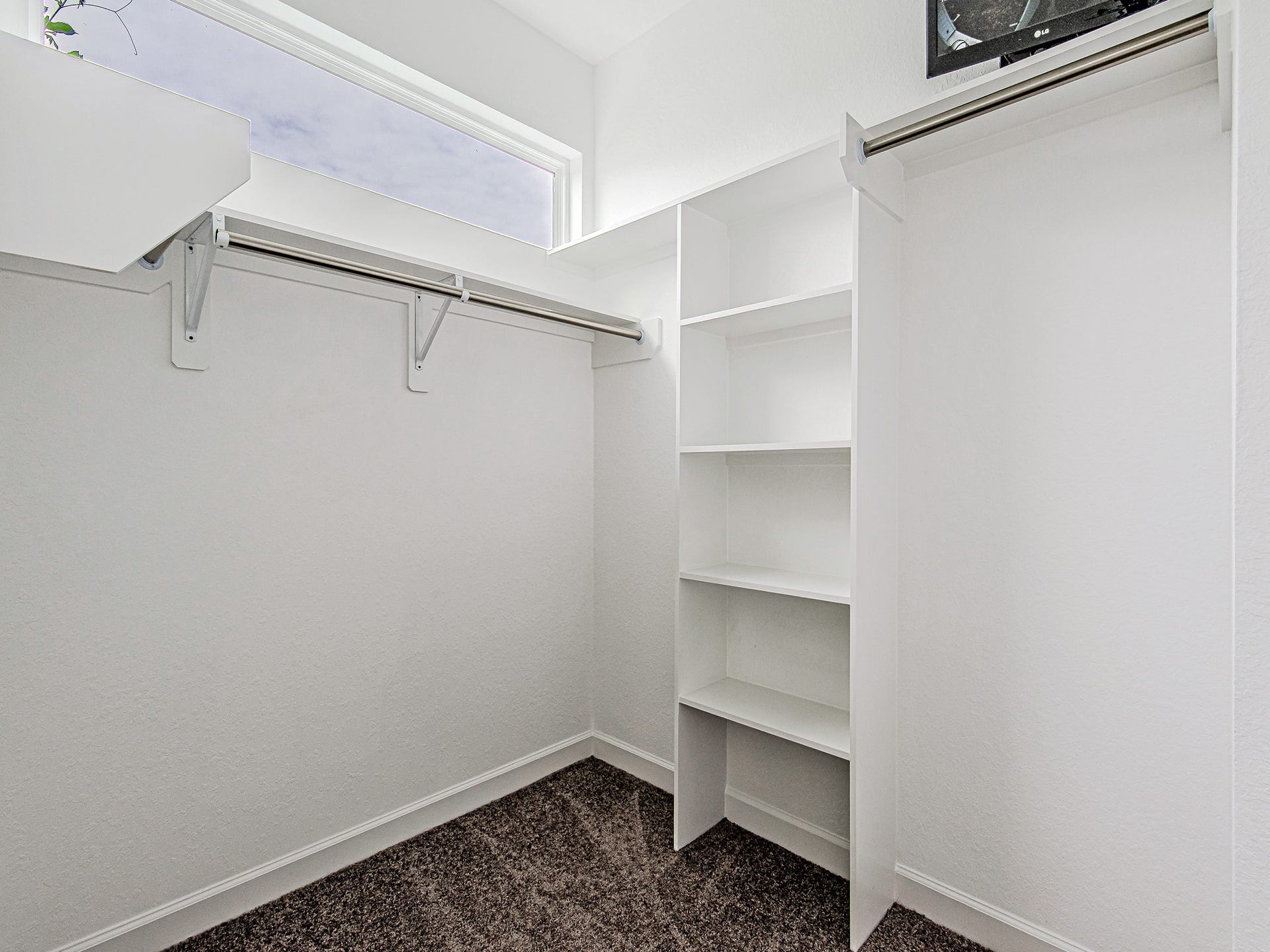 Generous walk-in closet with built-in shelving and ample storage space.