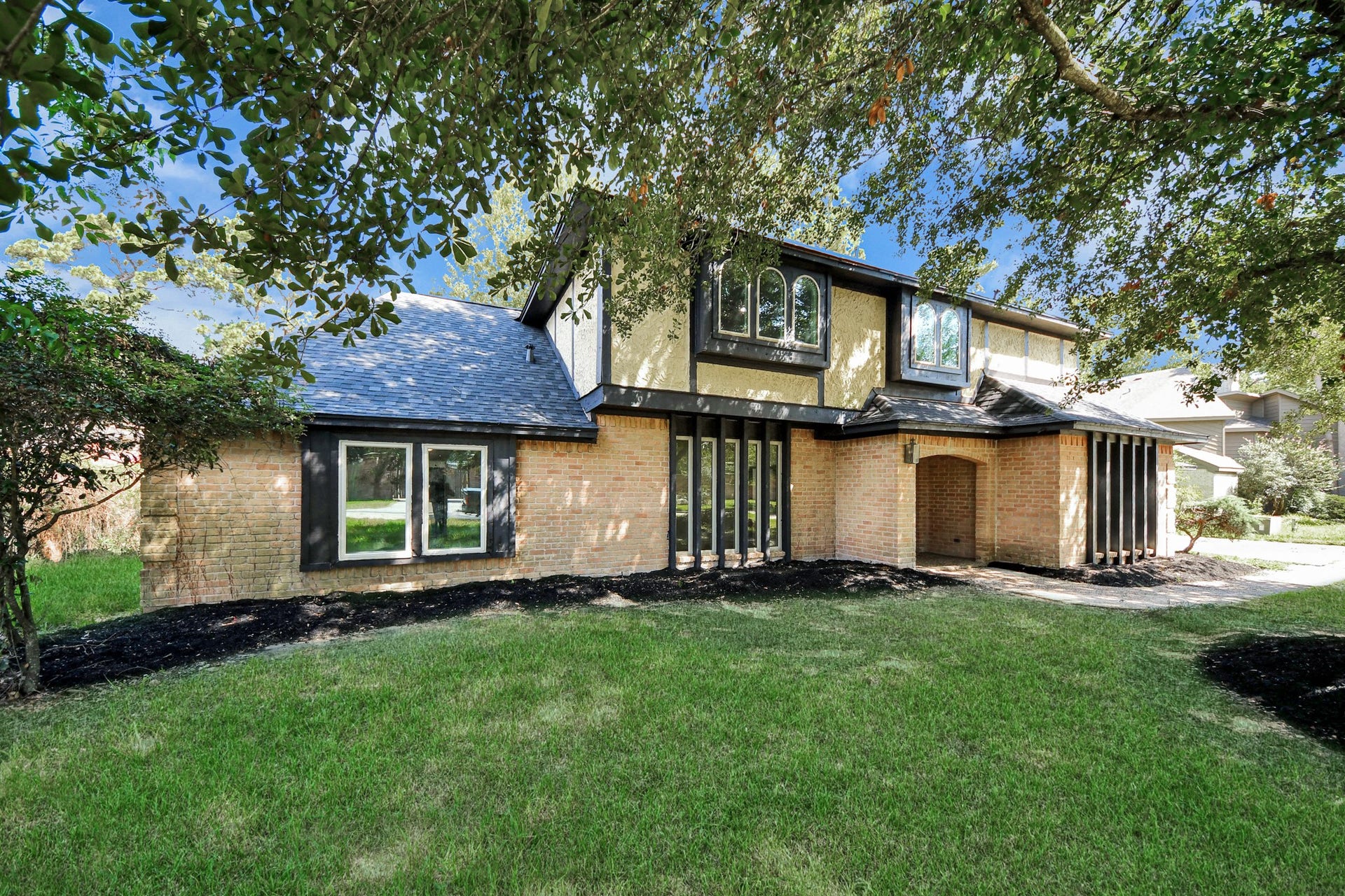 8503 Rebawood Drive, Humble, TX 77346 Charming two-story home with a mix of brick and wood accents, nestled among mature trees.
