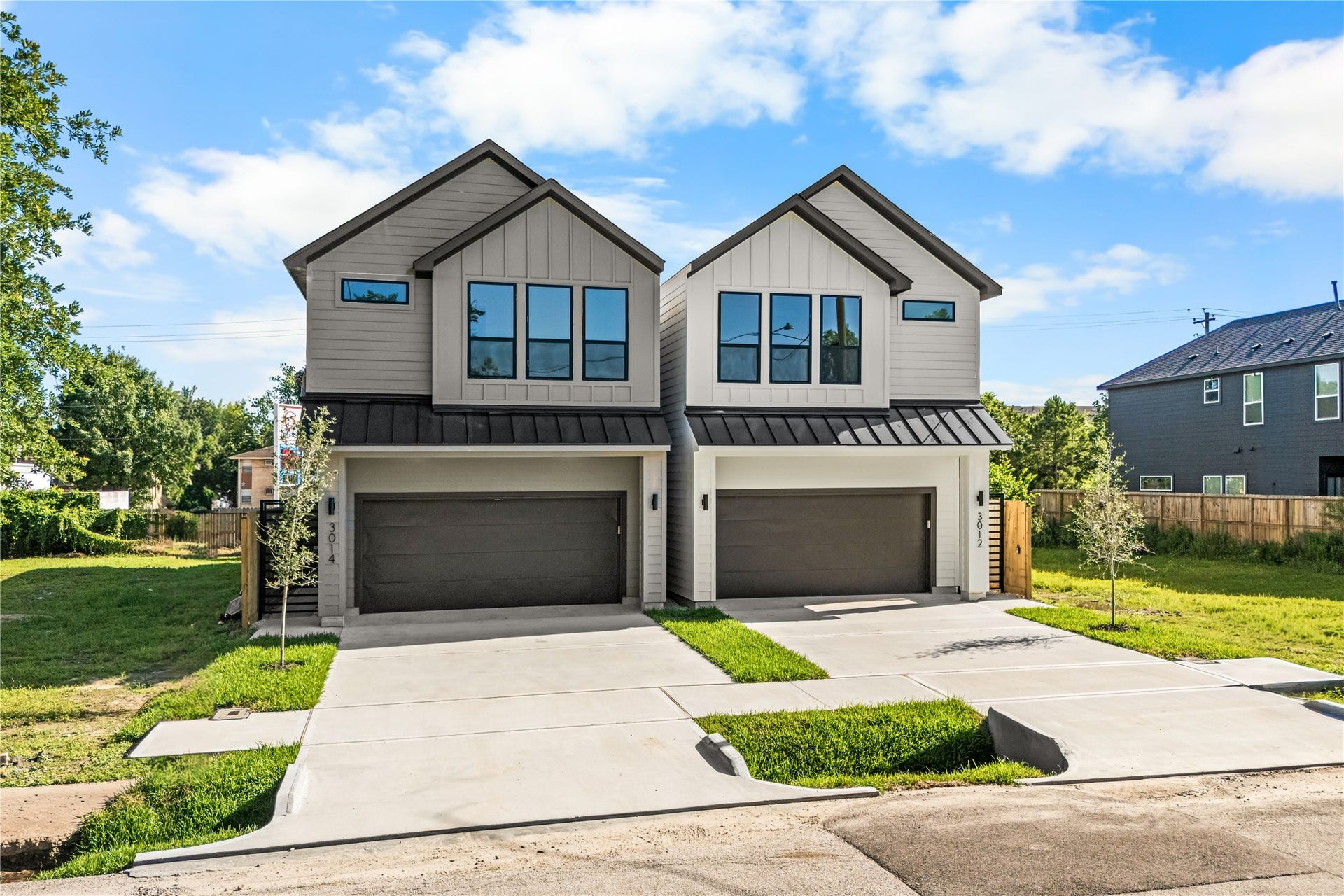 This home stands out immediately with its sharp design and clean contrast against the surrounding greenery. The dark-framed second-floor windows and deep charcoal garage doors give the exterior a bold, modern look. Its a sharp, well-designed property that you'll be proud to pull up to every day.