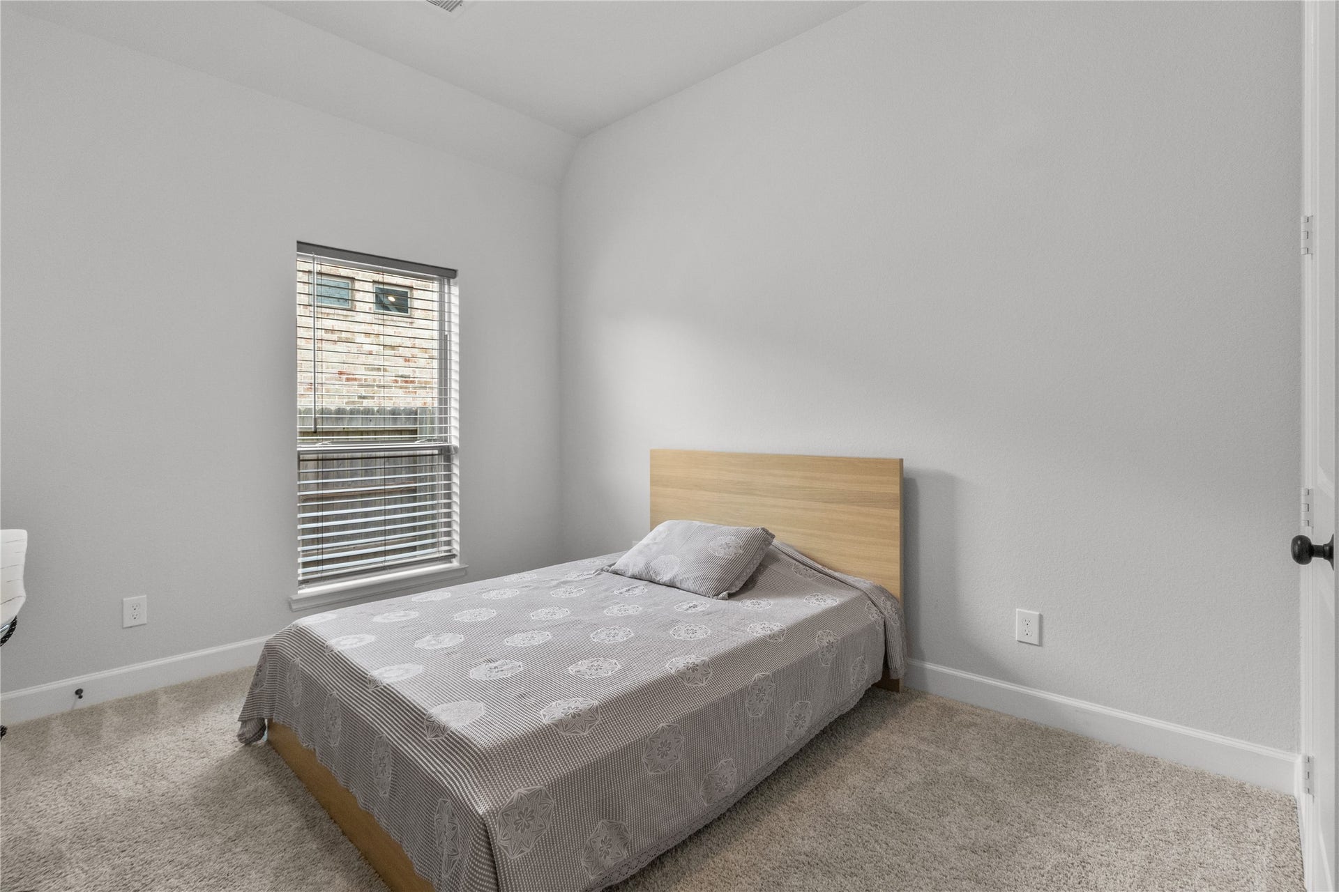 30427 Watershed Way, Fulshear, TX 77441 This bedroom features a clean, minimalist design with neutral walls, a large window for natural light, and soft carpeting.