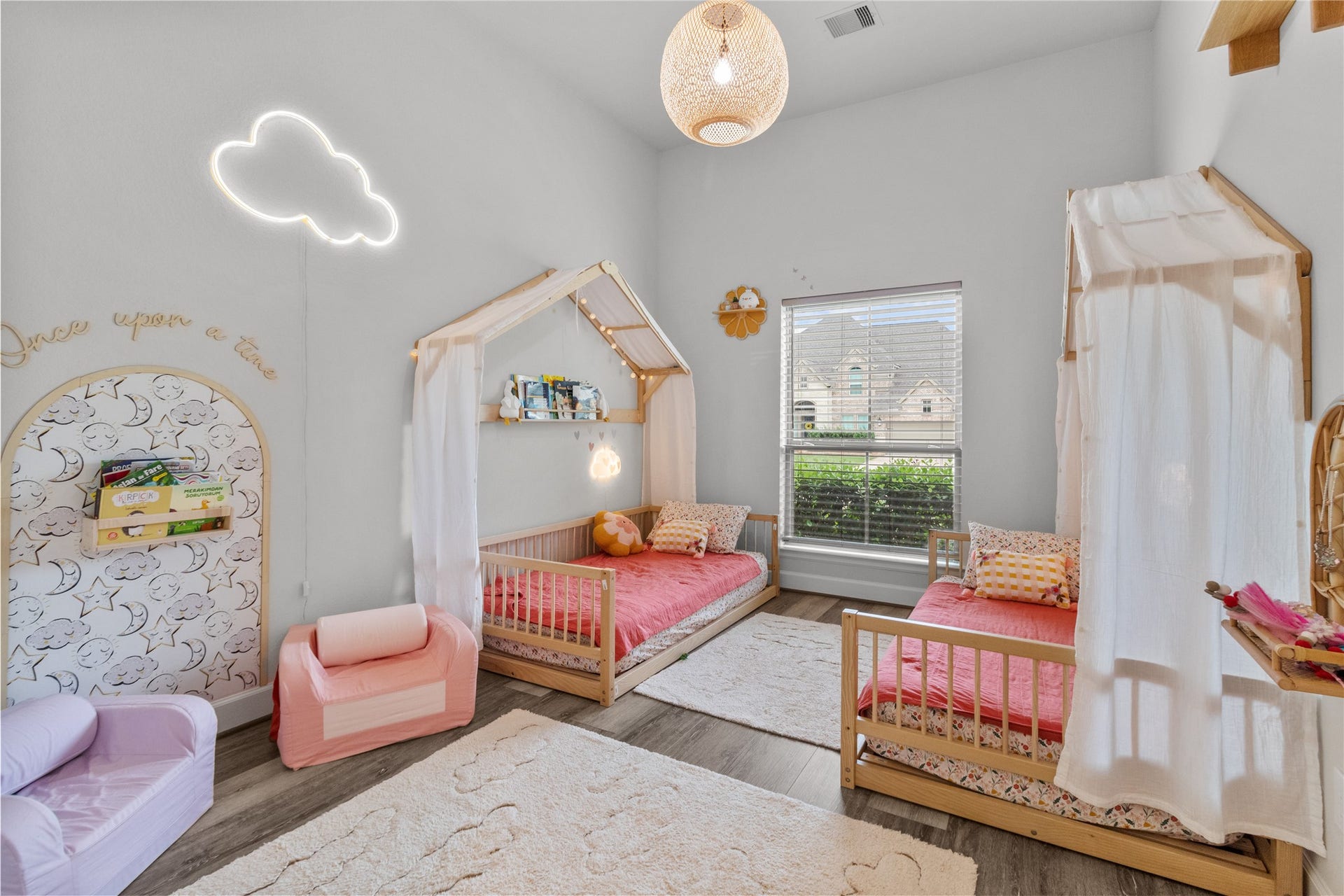 30427 Watershed Way, Fulshear, TX 77441 Charming children's bedroom. Features a bright window, playful cloud light, and whimsical wall designs, creating a welcoming and imaginative space.