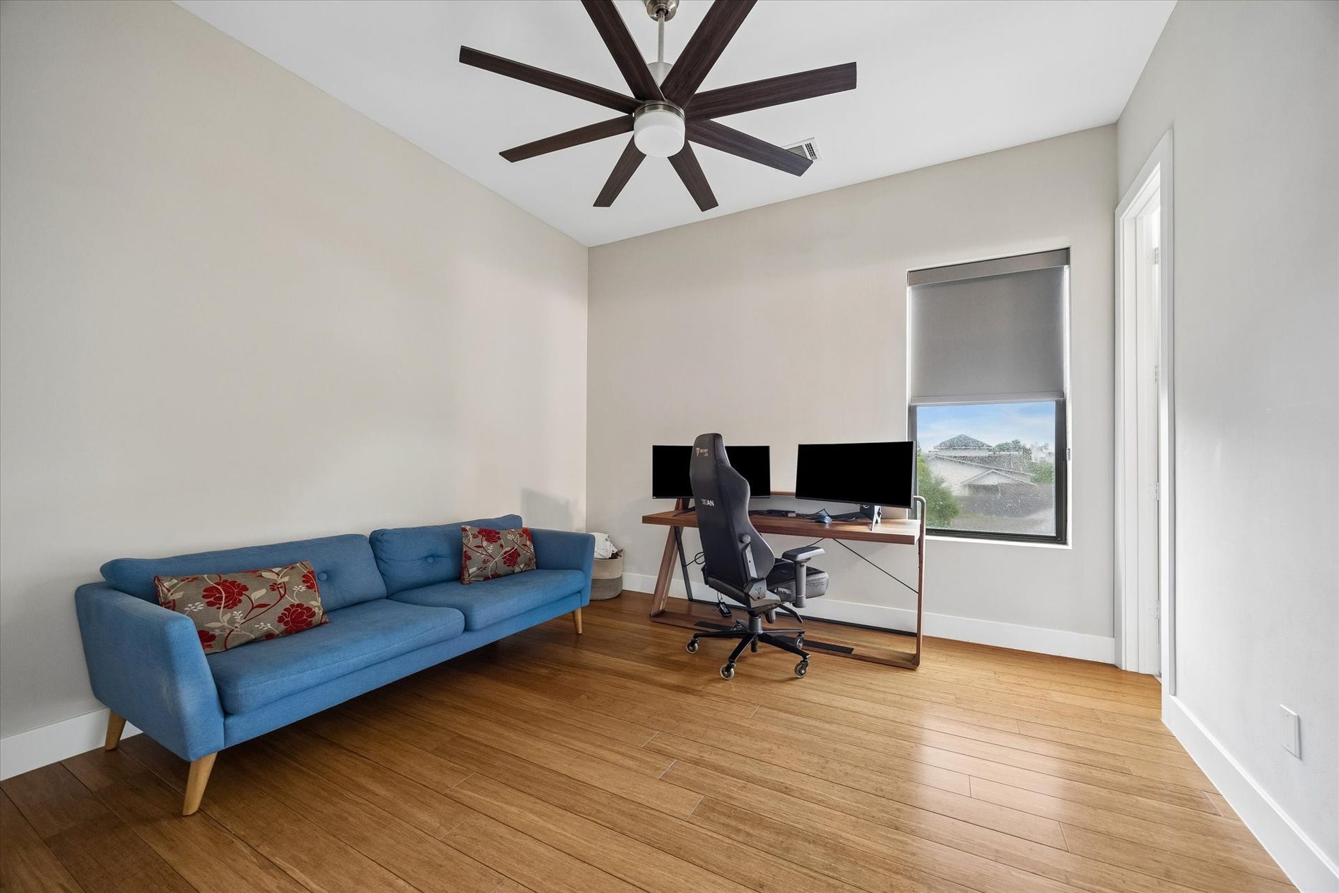 The third-floor guest suite offers a comfortable, private space for guests with warm wood flooring, custom window shades, and plenty of room to relax, work, or unwind away from the main living areas.