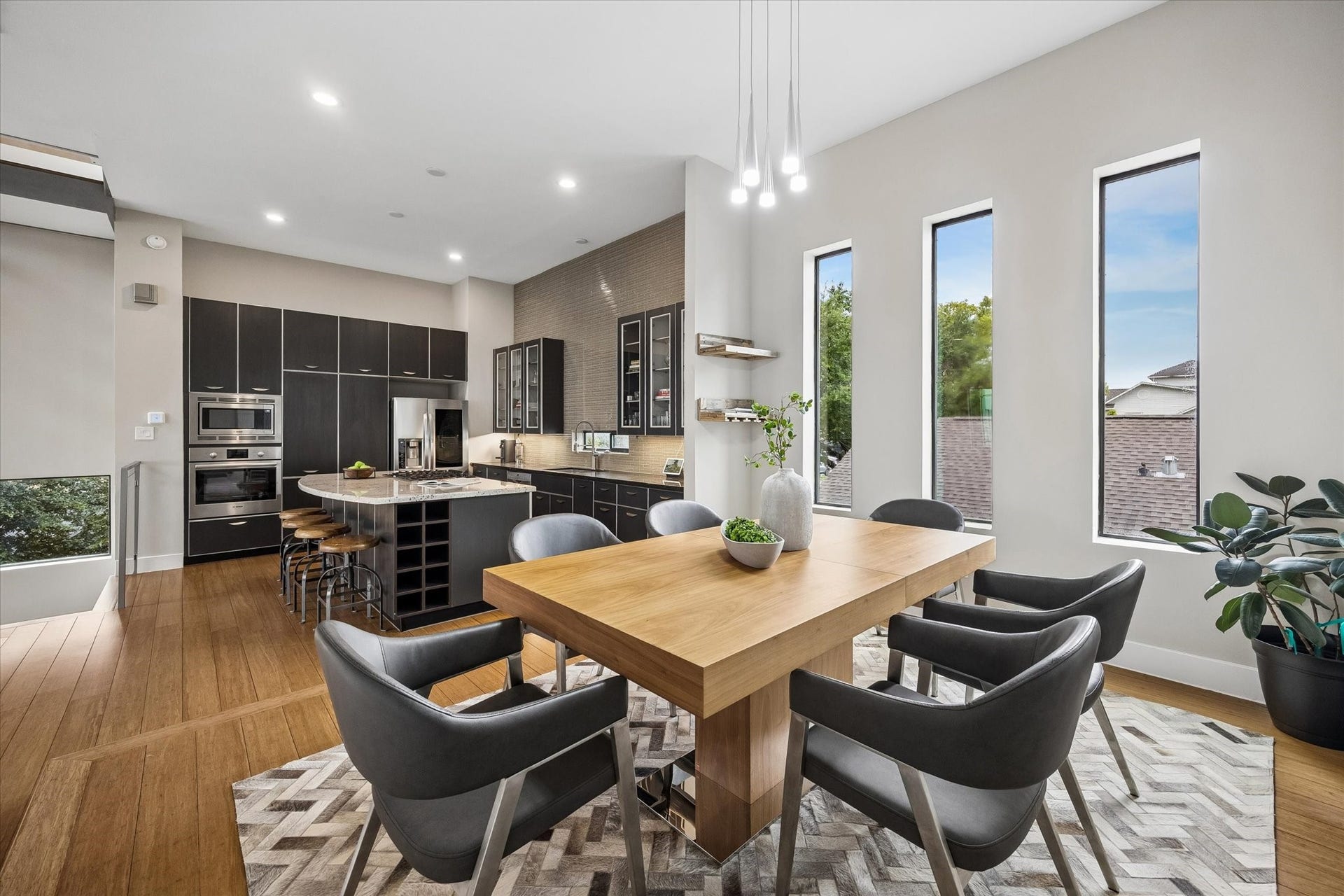 The second-floor offers an open, airy space where the dining room flows beautifully into the island kitchen, making the main living level feel connected and easy to live in. Tall windows, warm wood flooring, crisp finishes, and stylish lighting help the whole space feel fresh, inviting, and ready for gathering.