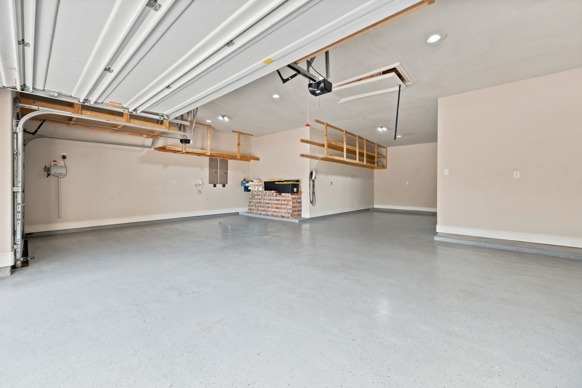 4 car garage!! THE DREAM!! Overhead storage shelving and TESLA Charging station.