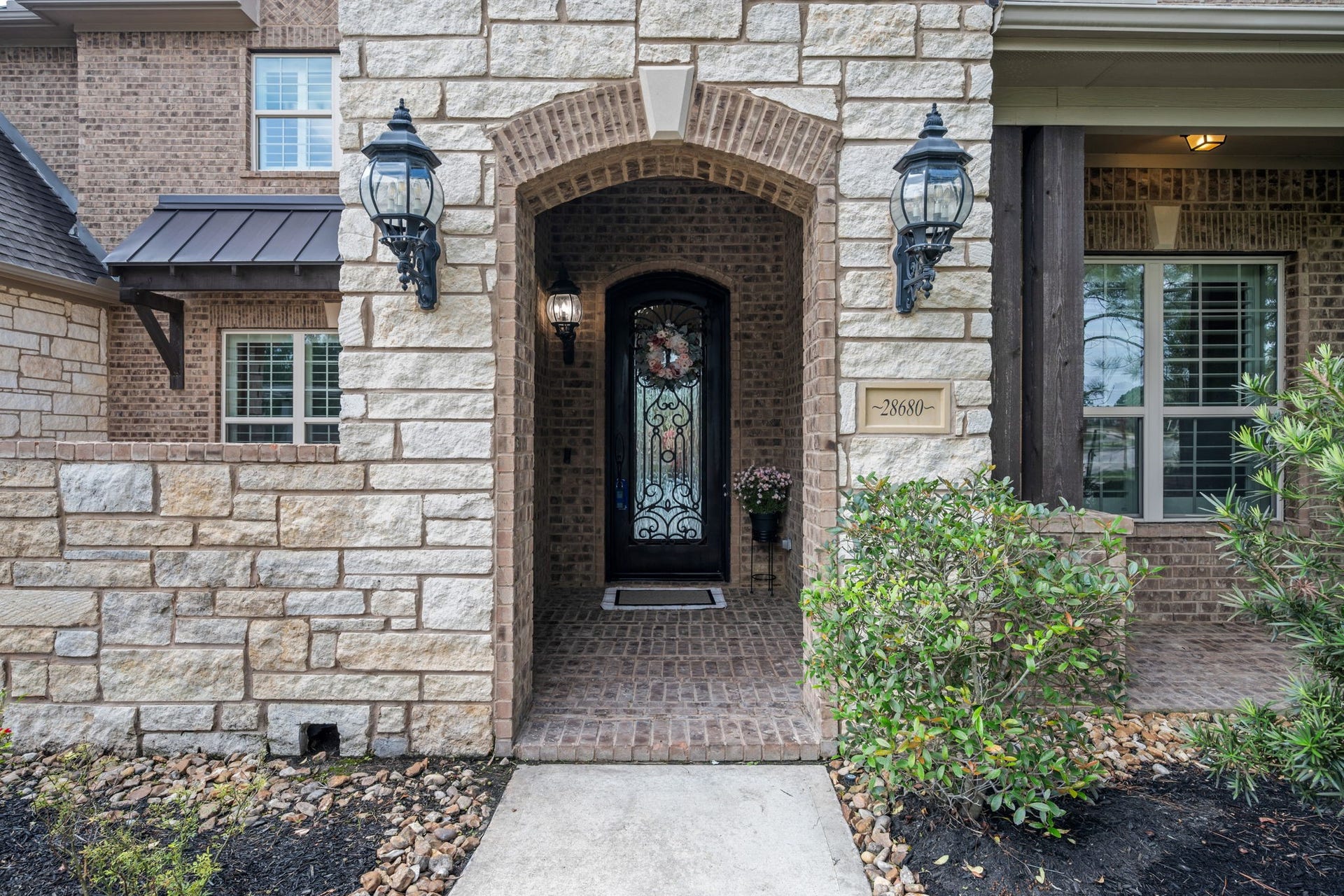 Grand Stone/Brick front entry with a covered front porch.