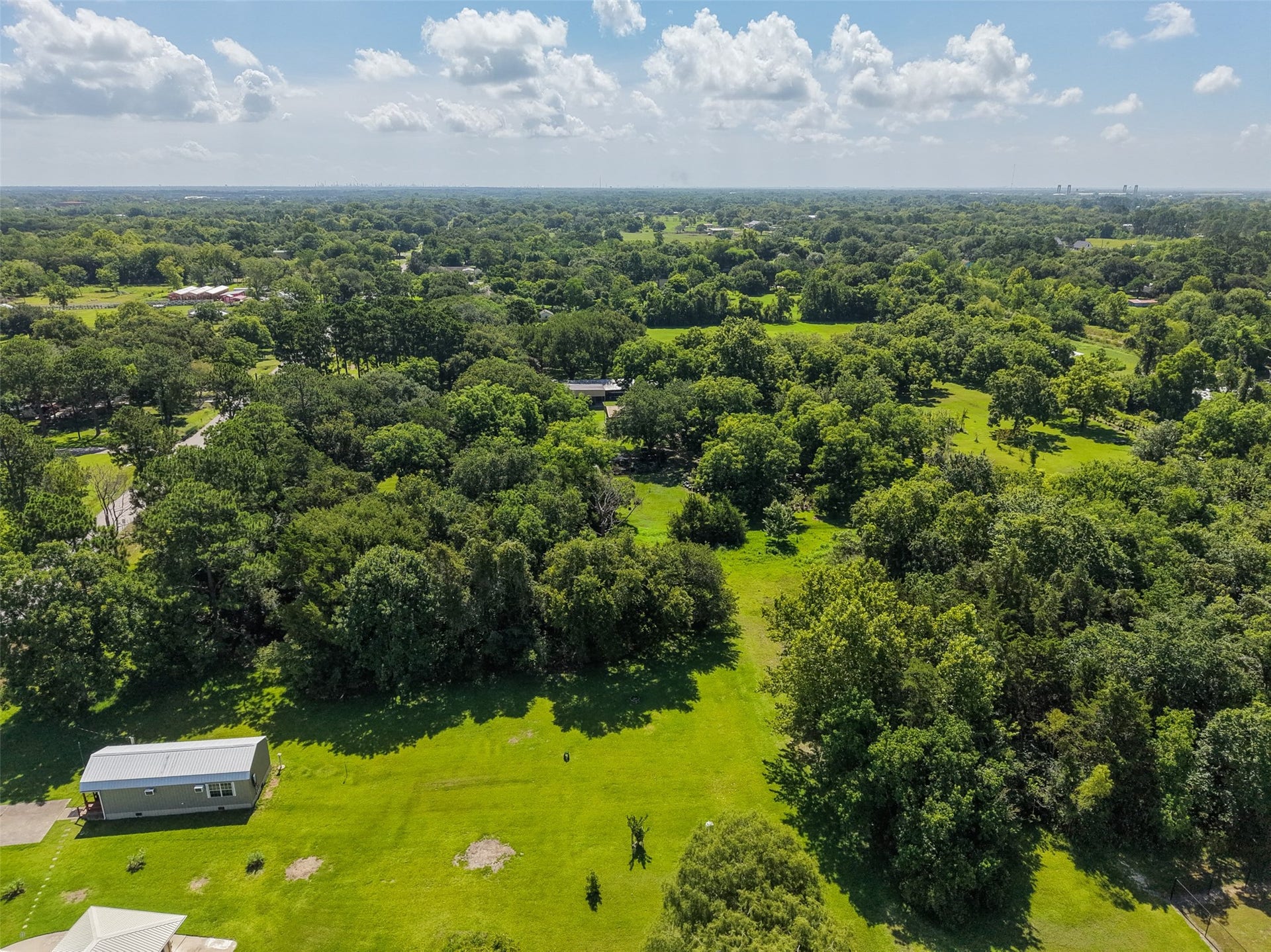 A sweeping aerial view captures the mature tree canopy that gives this property much of its character. Rather than starting with a completely cleared tract, a future owner has the opportunity to selectively preserve established hardwoods and incorporate them into the design of a residence, driveway and outdoor spaces. The property's substantial depth allows improvements to be positioned well away from the street for additional privacy.