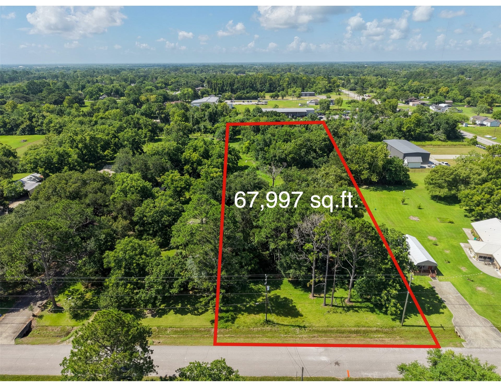 Outlined from above, the property's substantial proportions become clear: approximately 111' wide by 612' deep, providing 1.56 acres of versatile space. The long rectangular configuration offers flexibility when planning a homesite, workshop, additional improvements or expansive outdoor areas. Mature hardwoods provide an established natural setting, while open portions of the tract offer room to envision future development.