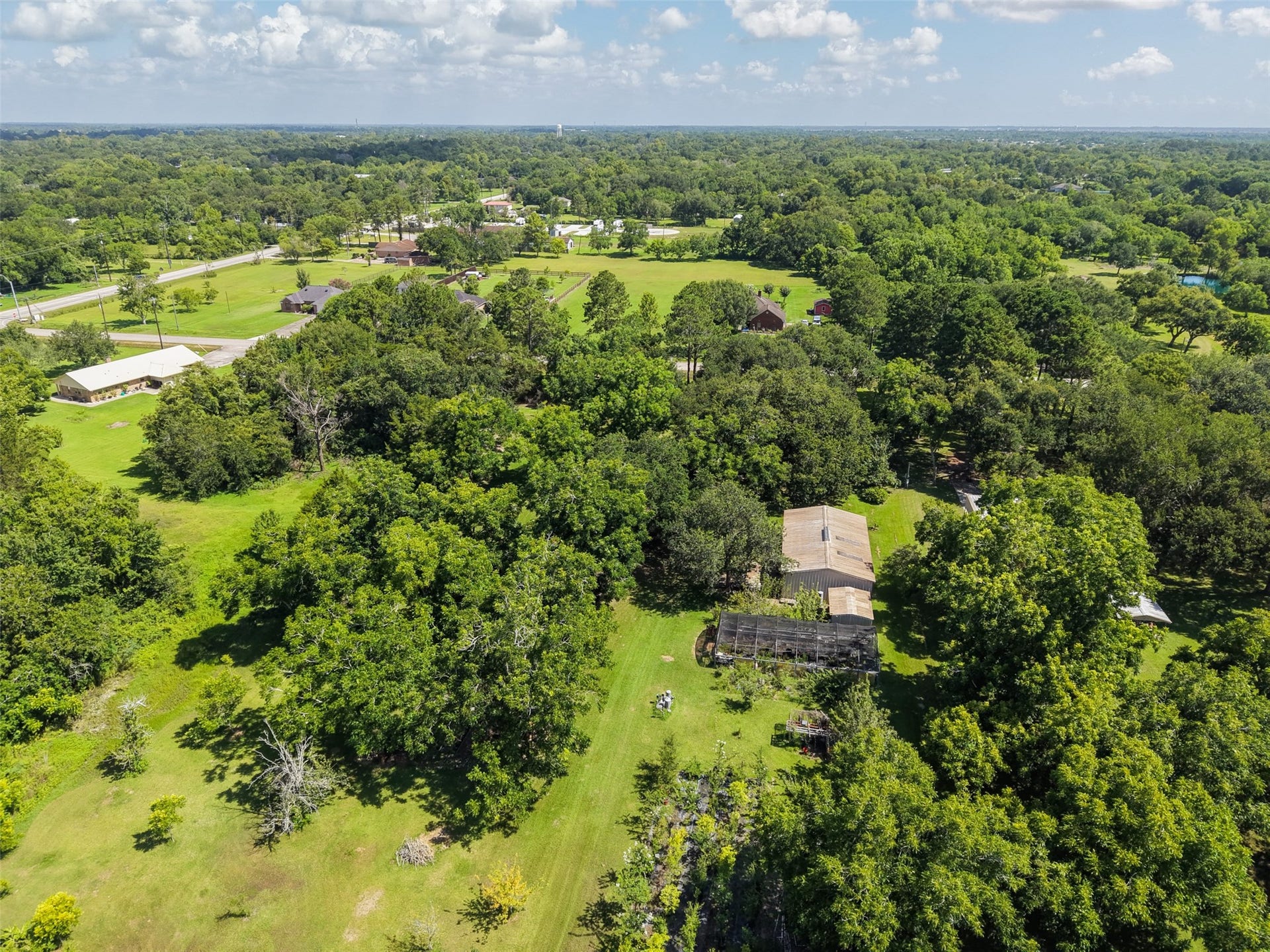 With approximately 67,997 sq. ft., the property offers room to create more than a conventional homesite. This aerial view illustrates the surrounding open space and established tree canopy that could complement a custom residence, workshop, pool, gardens or extensive outdoor living. The property's long rectangular dimensions also allow future improvements to be thoughtfully separated rather than crowded together.
