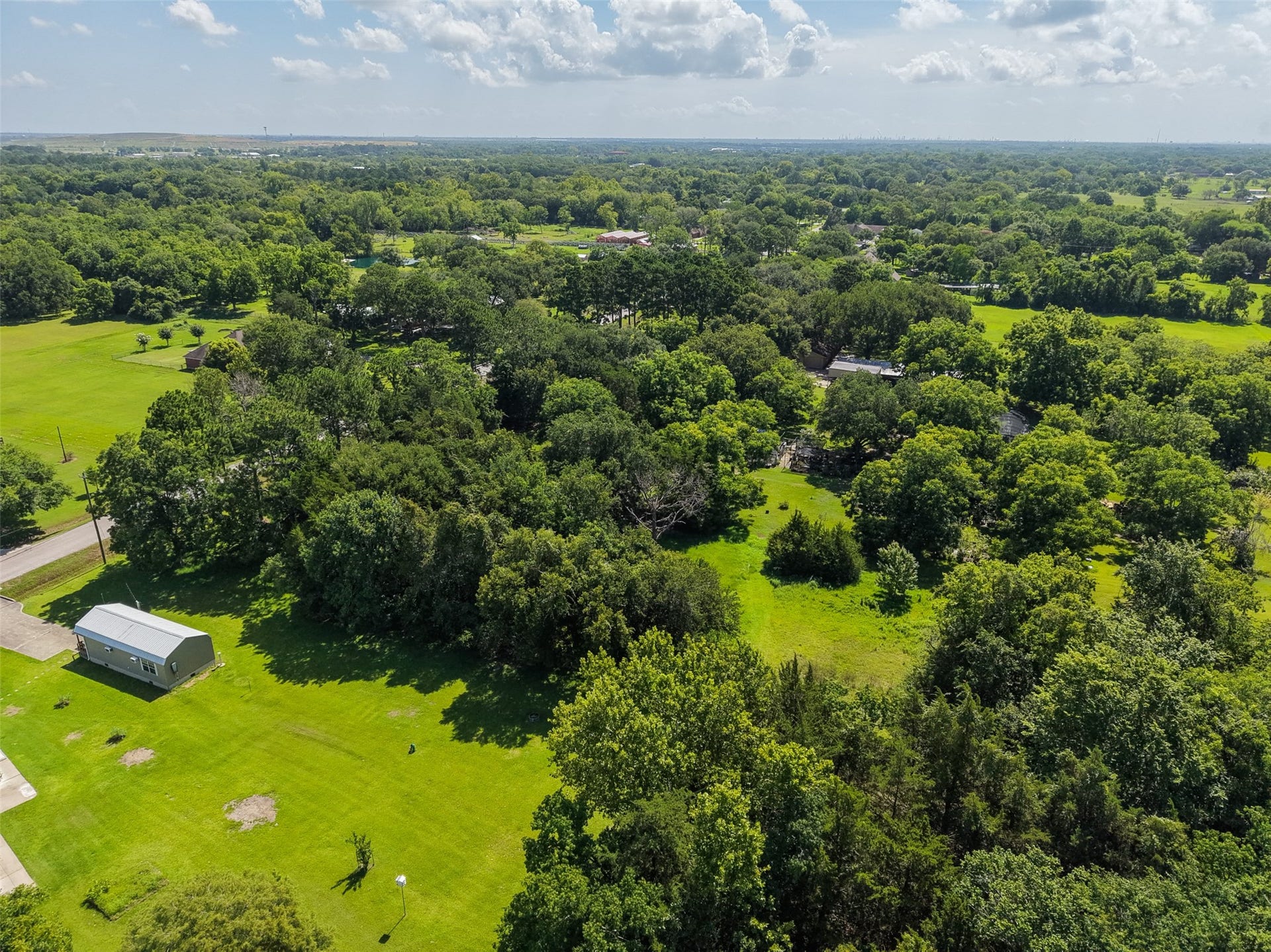 This elevated view highlights the low-density character surrounding the property, where larger lots, mature trees and open green space create a distinctly different environment from a typical subdivision. The property has no HOA, allowing buyers to explore their vision without an additional homeowners association, while restrictions and intended uses should be independently verified.