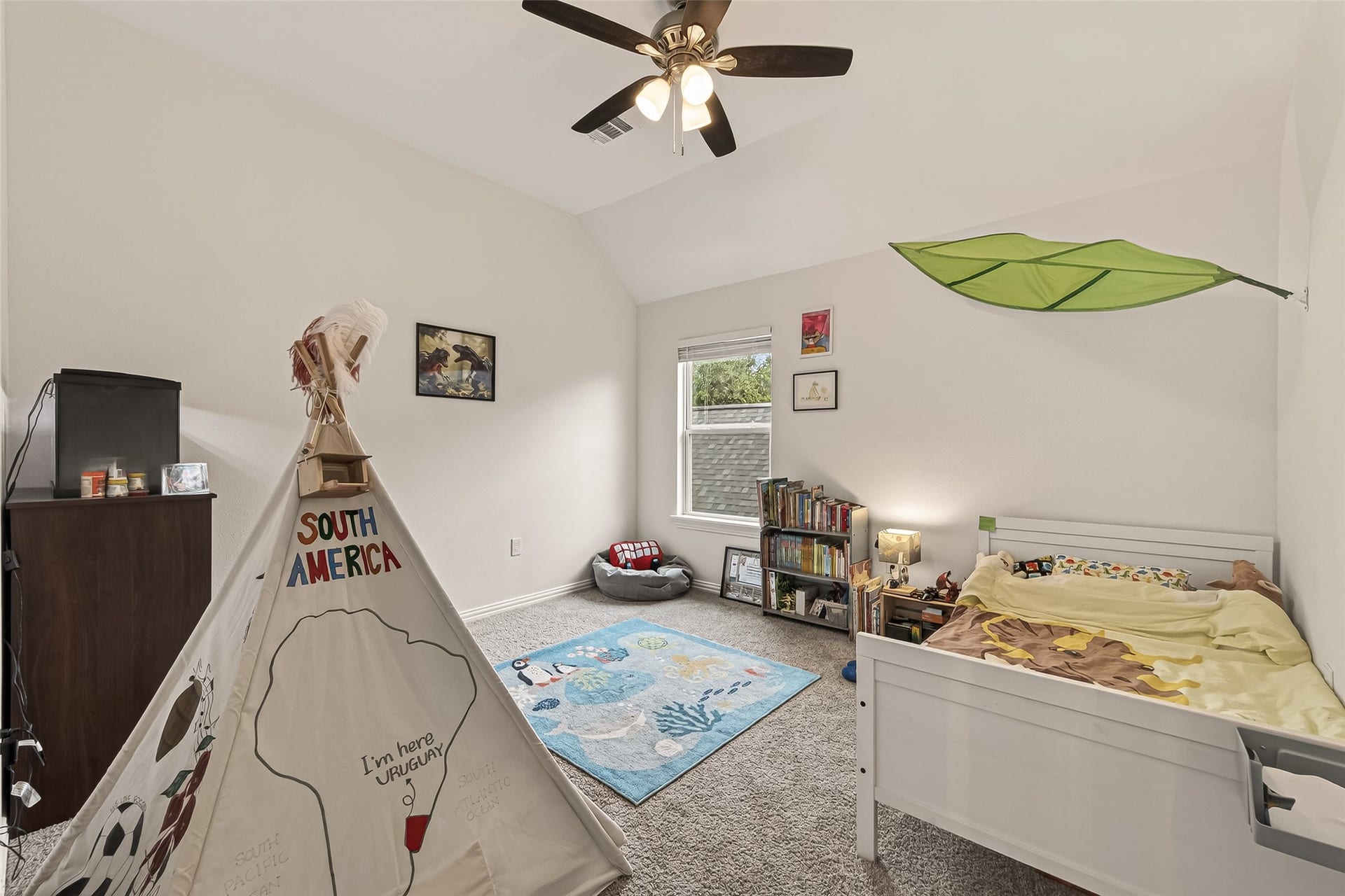 4423 Parkwater Cove Court SE, Sugar Land, TX 77479 This photo showcases a bright, cozy bedroom with vaulted ceilings. It features a a ceiling fan, and a window letting in natural light.