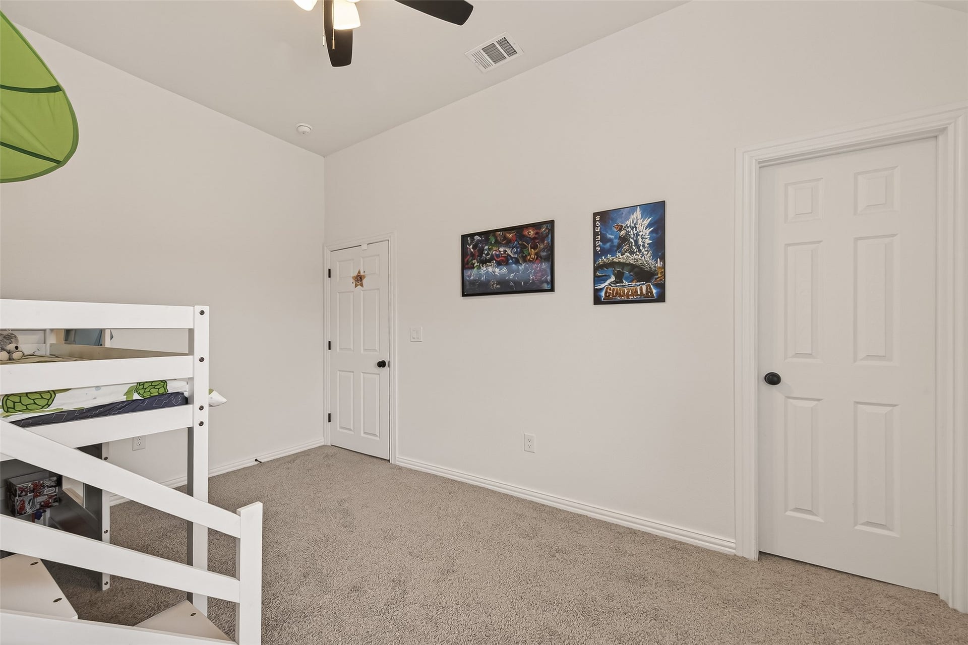 4423 Parkwater Cove Court SE, Sugar Land, TX 77479 This photo shows a bright, carpeted bedroom with white walls with a ceiling fan and two doors, offering a clean and cozy space.