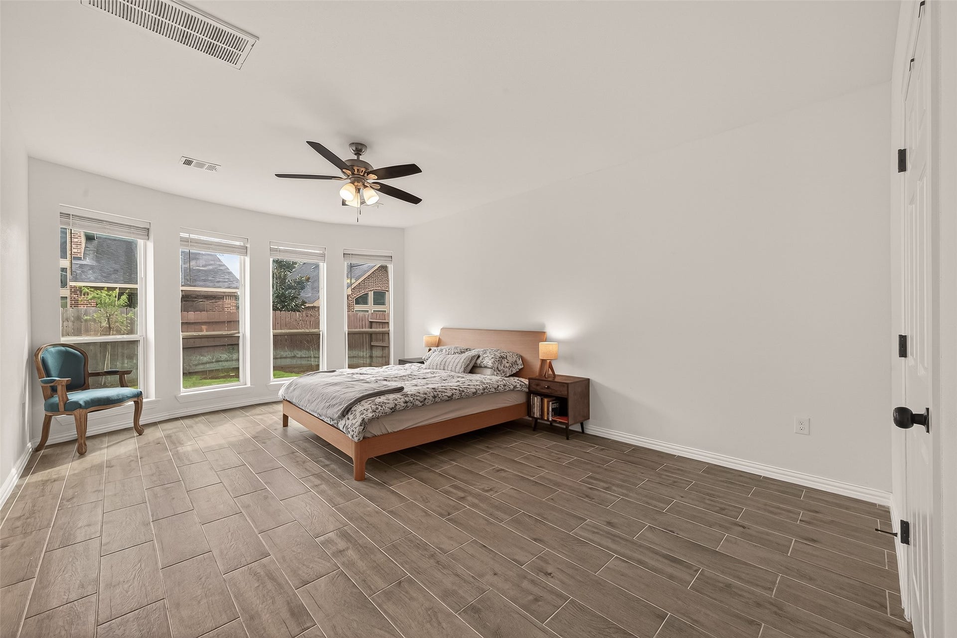 4423 Parkwater Cove Court SE, Sugar Land, TX 77479 This spacious bedroom features large windows offering plenty of natural light, a ceiling fan, and a modern wood-look tile floor. The neutral walls add a bright and airy feel.