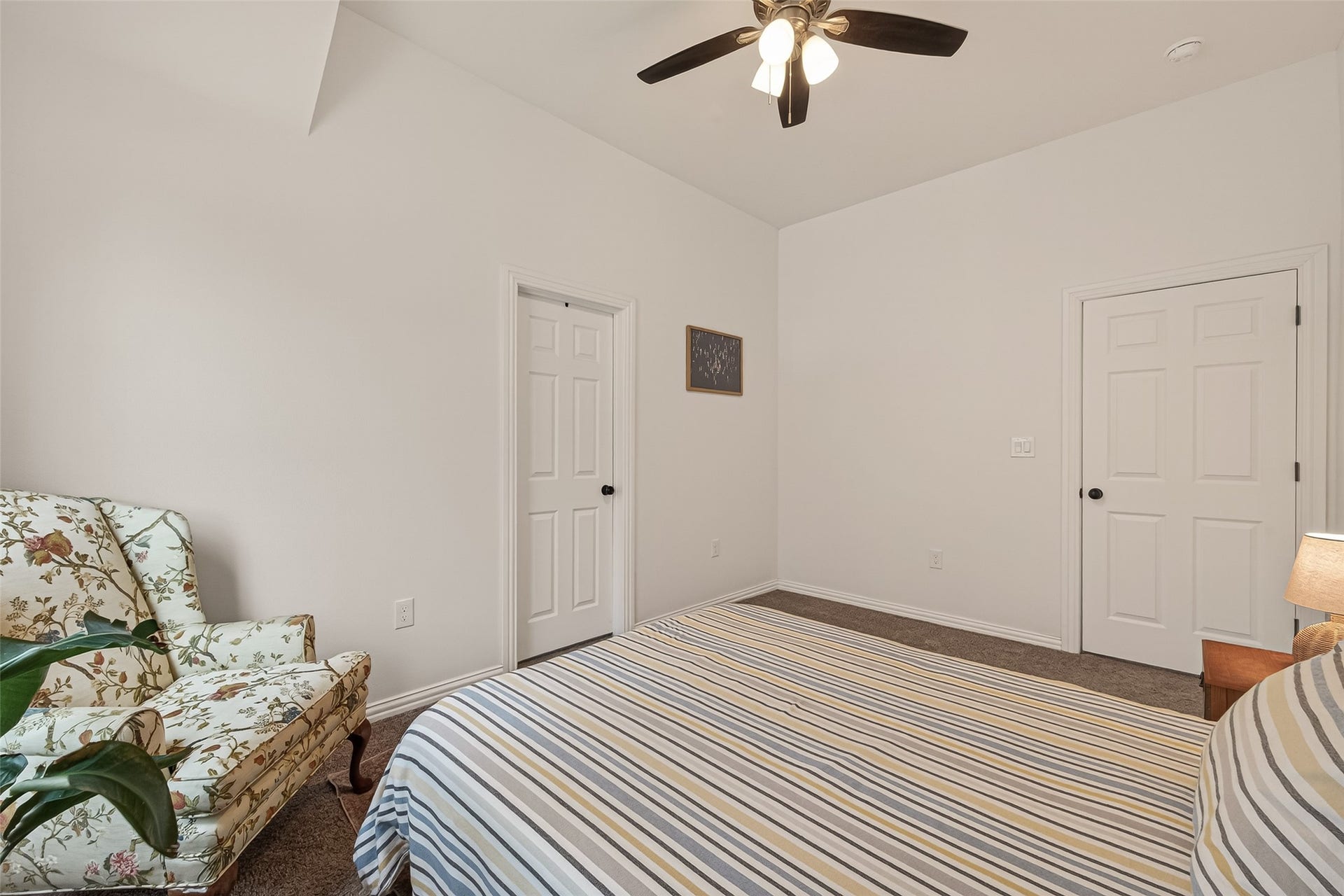 4423 Parkwater Cove Court SE, Sugar Land, TX 77479 This bedroom features neutral walls, a ceiling fan, and a cozy atmosphere. It leads two doors, for a closet and bathroom. The space is well-lit and inviting.