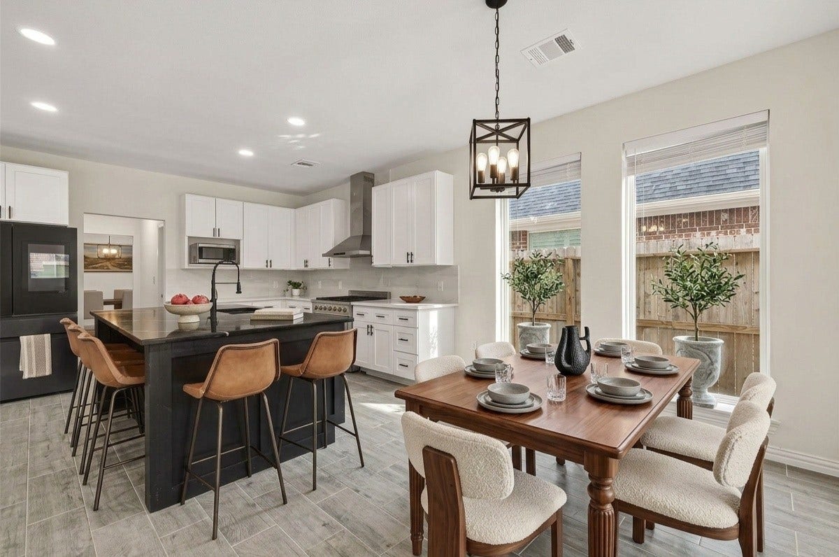 4423 Parkwater Cove Court SE, Sugar Land, TX 77479 Bright and modern kitchen with an open layout, featuring a large island with seating, sleek black and white cabinetry, stainless steel appliances, and a cozy dining area by the windows.