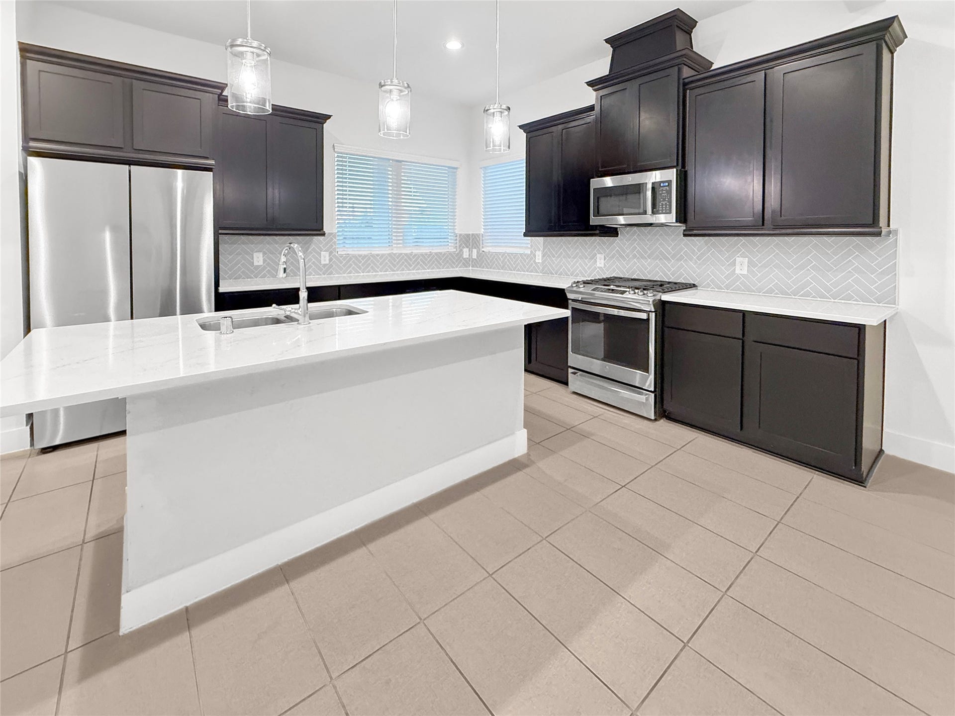 9407 Lantern Light Drive, Missouri City, TX 77459 Sleek kitchen cabinetry, stainless steel appliances, quartz countertops, and abundant preparation space.