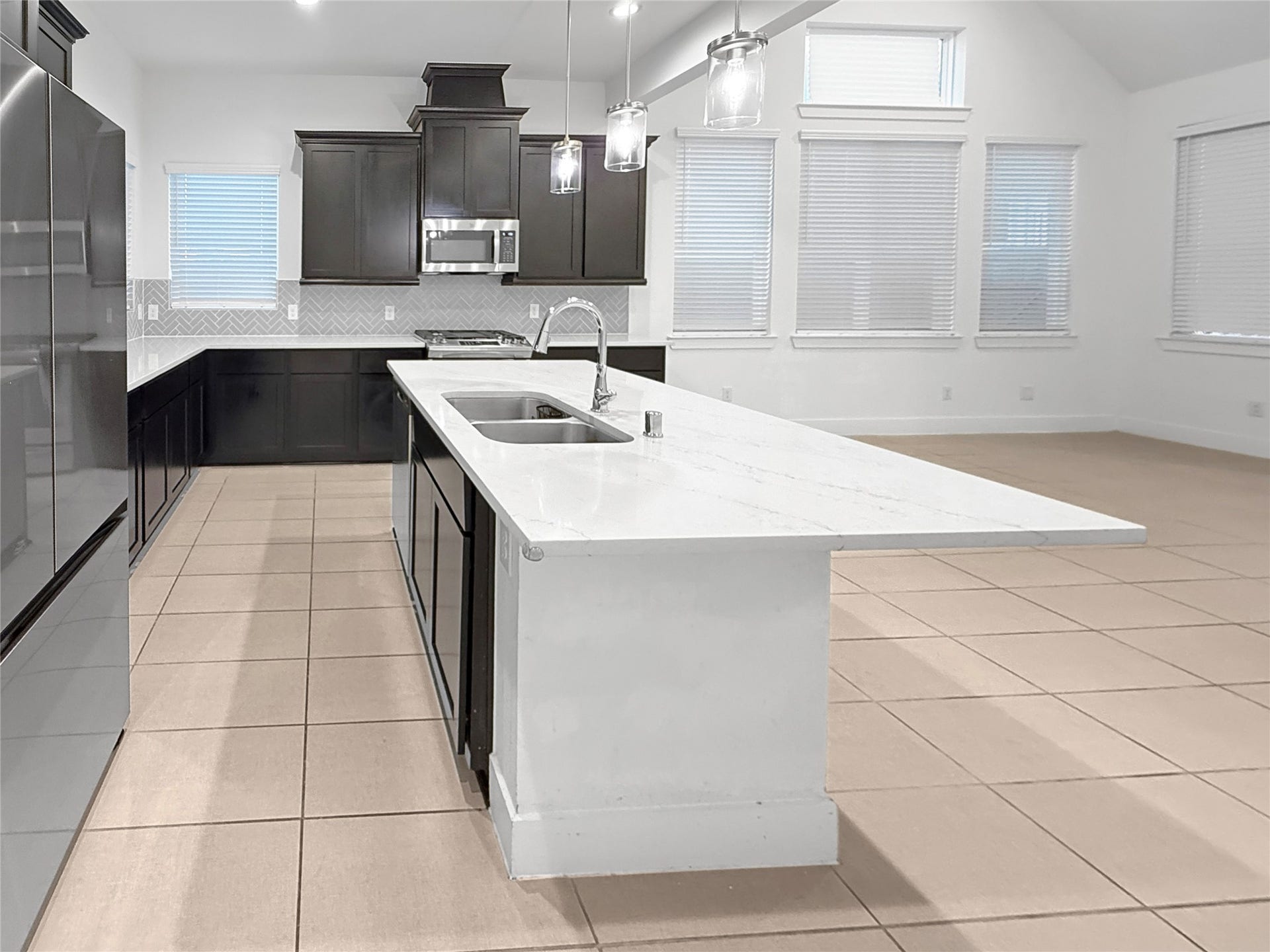 9407 Lantern Light Drive, Missouri City, TX 77459 Open-concept kitchen with a large island overlooking the main living area.