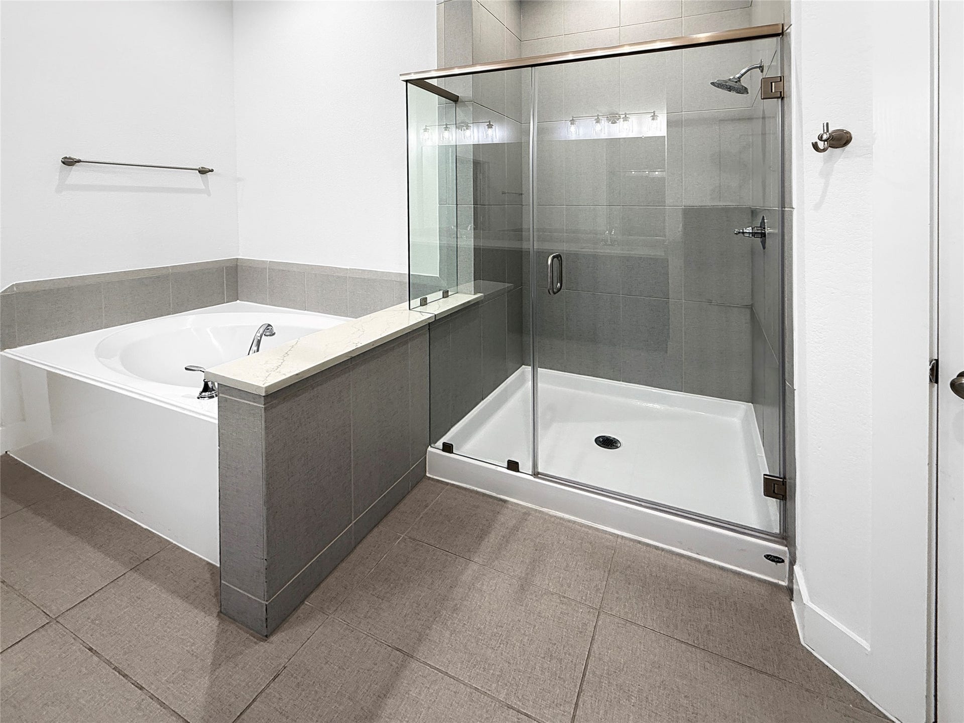 9407 Lantern Light Drive, Missouri City, TX 77459 Primary bathroom featuring a glass-enclosed shower and soaking tub.