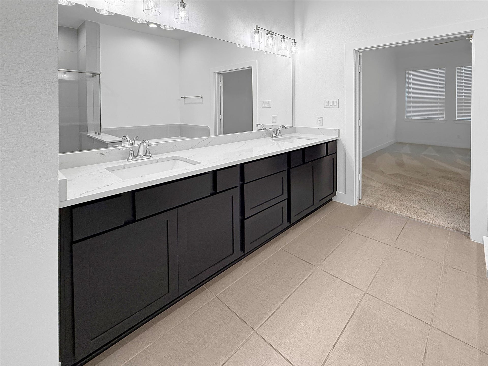 9407 Lantern Light Drive, Missouri City, TX 77459 Primary bathroom featuring double sinks, quartz countertops, and generous vanity storage.