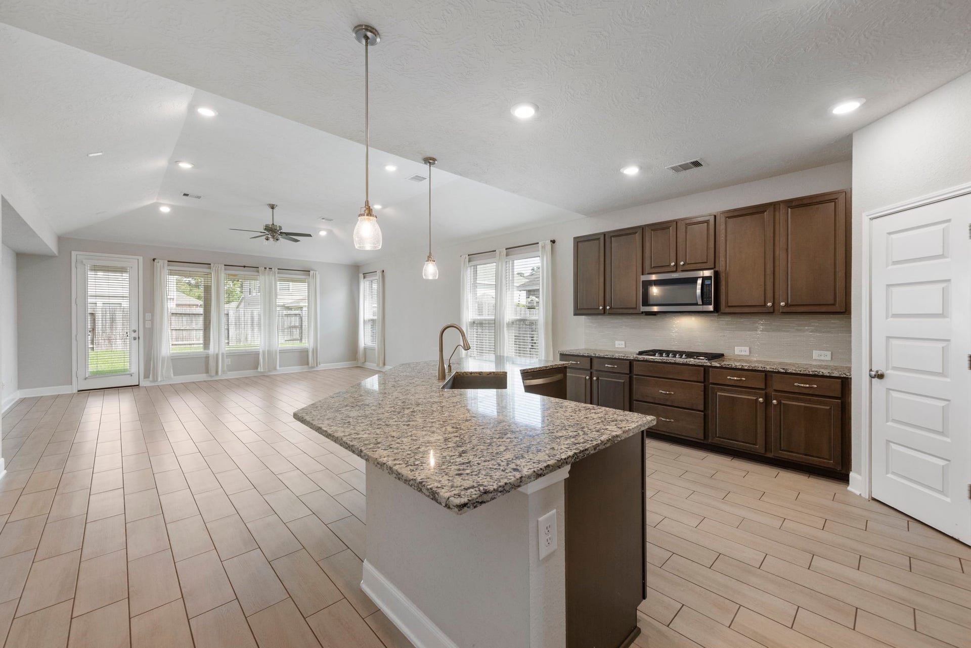8731 Ute Creek Lane, Magnolia, TX 77354 Open kitchen with pendant lighting overlooking the breakfast area and family room