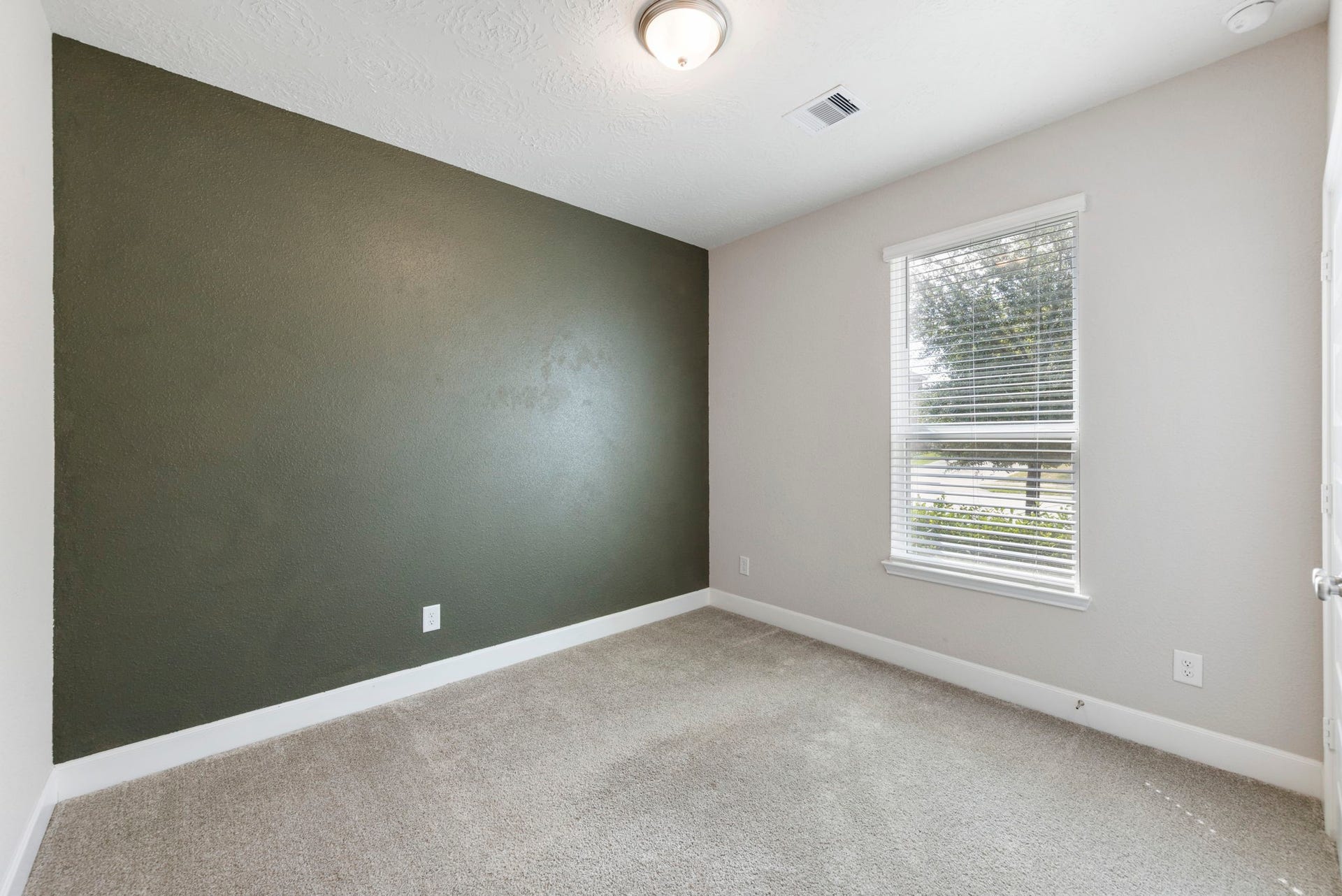 8731 Ute Creek Lane, Magnolia, TX 77354 Spacious secondary bedroom with a bold accent wall and plush carpet