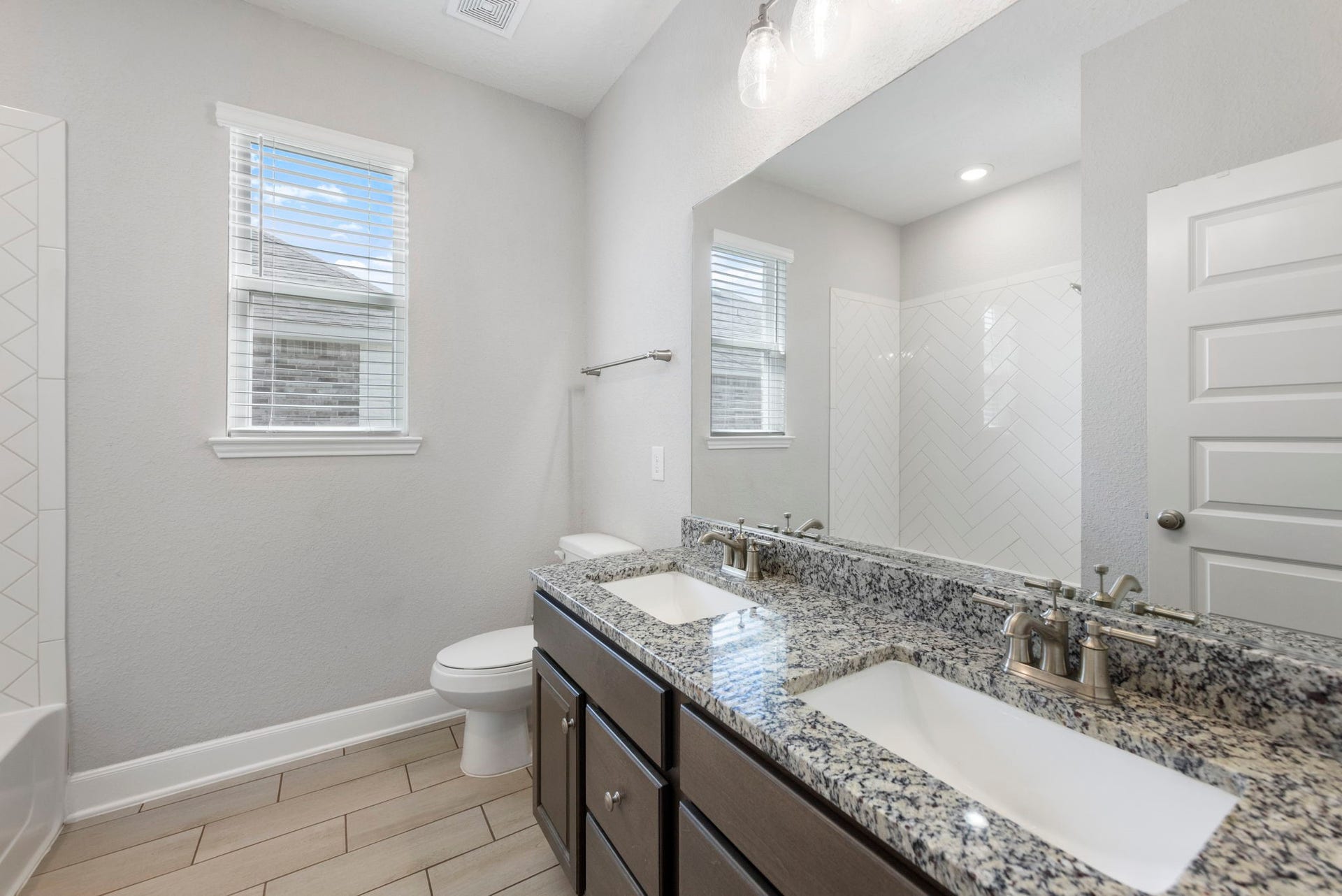 8731 Ute Creek Lane, Magnolia, TX 77354 Secondary bathroom w/ double granite vanity and tiled tub/shower combo, convenient to the secondary bedrooms.