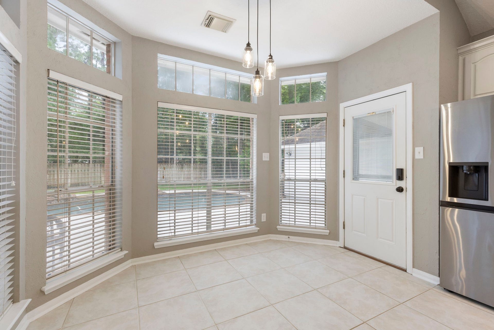 27 Stargazer Place, The Woodlands, TX 77381 The Floor to Ceiling windows overlooks the sparkling pool, and allows quick access to the backyard.