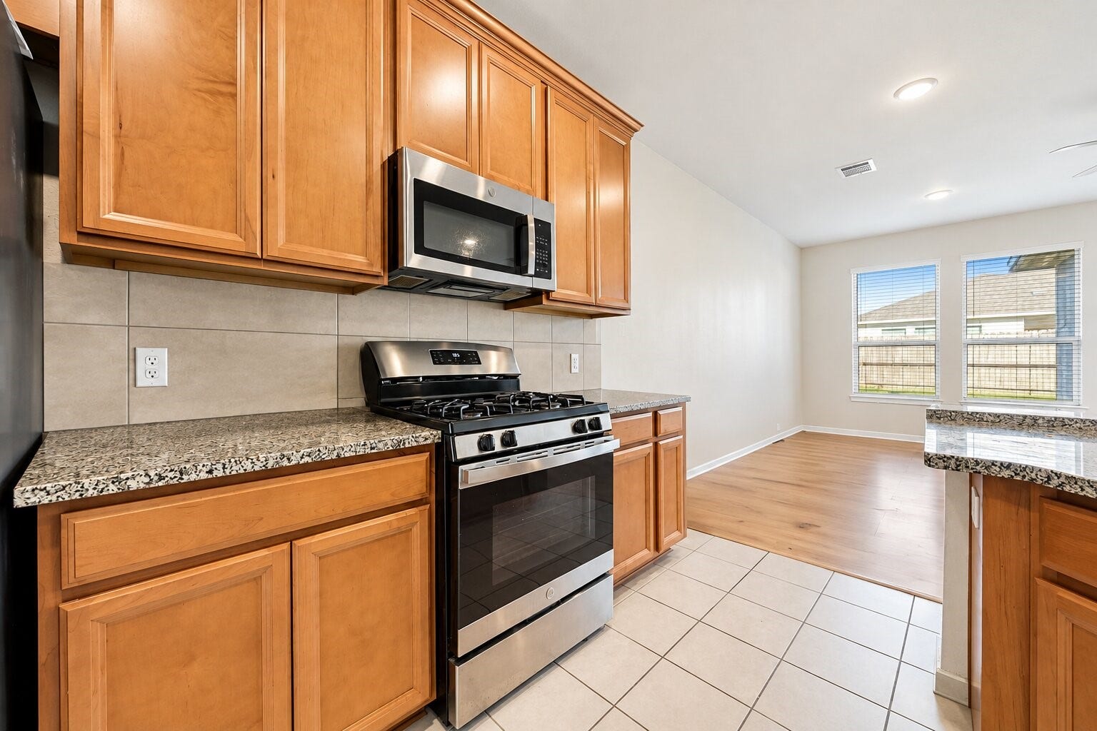 8106 Colony Chase Court, Richmond, TX 77407 Kitchen featuring wood cabinetry, granite countertops, and stainless steel appliances.