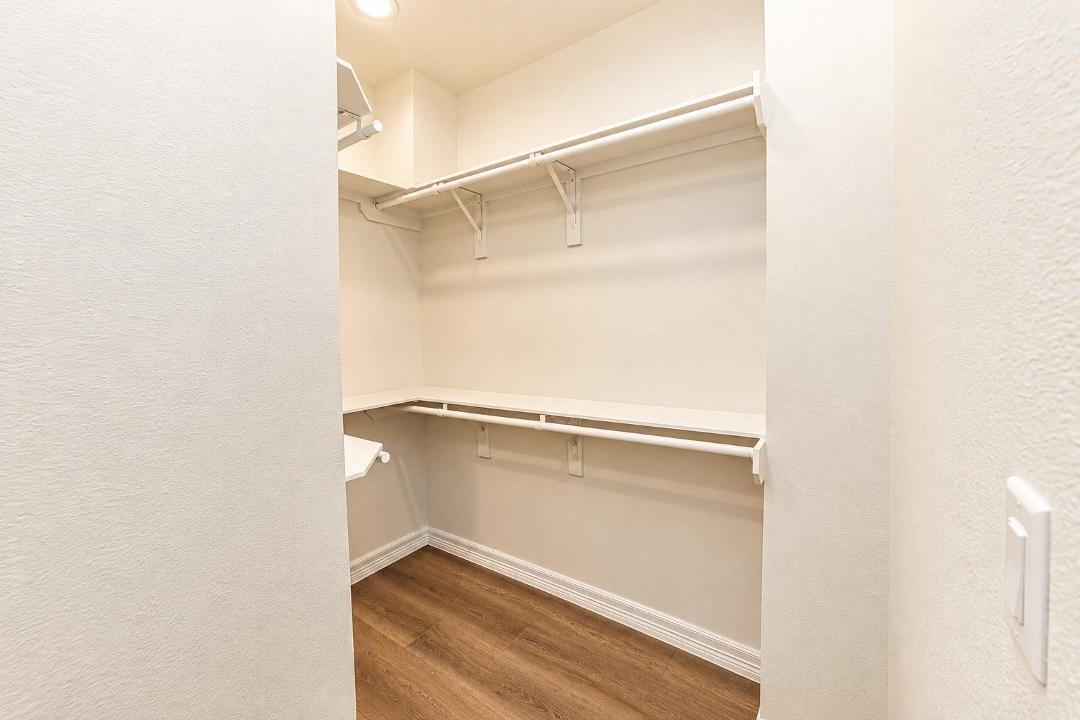 3252 Creekmont Drive, Houston, TX 77091 Spacious walk-in closet with ample shelving and hanging space, featuring sleek hardwood flooring and soft lighting.