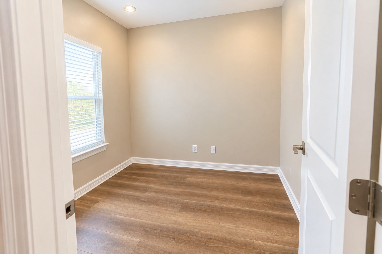 3252 Creekmont Drive, Houston, TX 77091 Bright room with warm wood floors, neutral walls, and ample natural light from a large window, perfect for a cozy office.