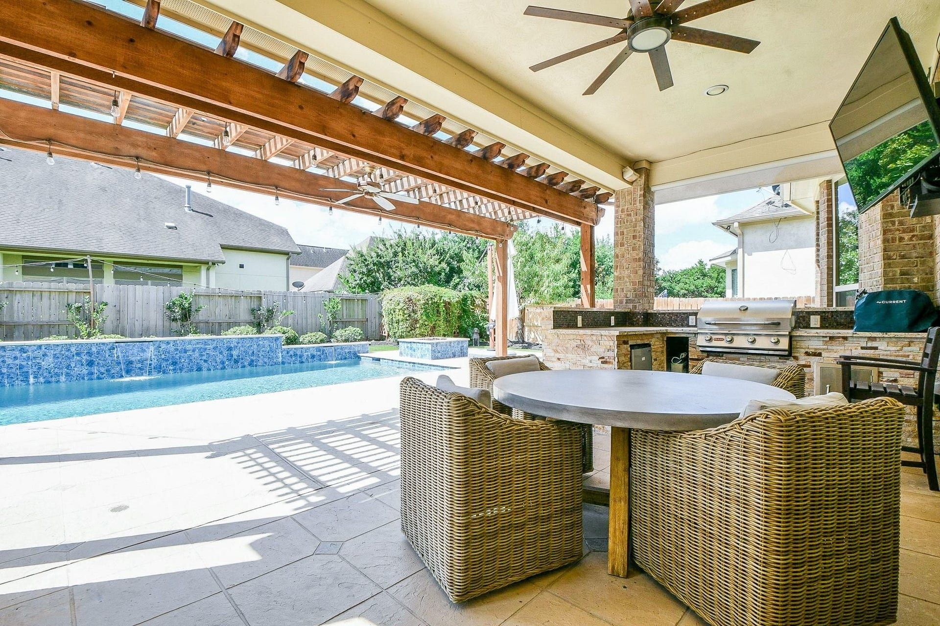 11410 Sardinia Drive, Richmond, TX 77406 Step outside to your private backyard retreat, featuring a large covered patio, outdoor kitchen, extended covered area, and a gorgeous saltwater pool with hot tub, water features, and firepitperfect for relaxing and entertaining.