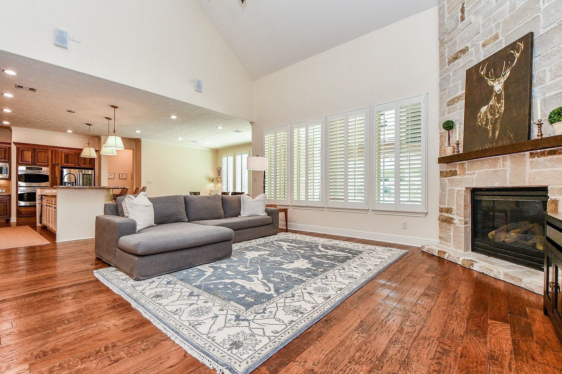 11410 Sardinia Drive, Richmond, TX 77406 Another view of the living room highlights the plantation shutters, built-in surround sound speakers, and spacious open-concept layout connecting seamlessly to the kitchen and dining areas.