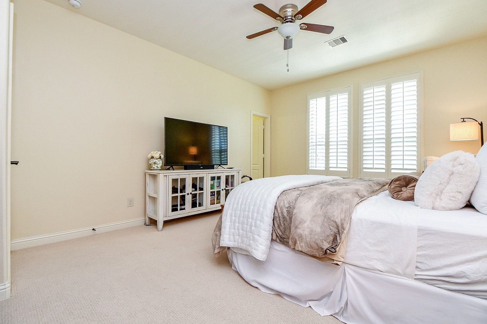 11410 Sardinia Drive, Richmond, TX 77406 Upstairs guest bedroom features an ensuite bathroom, plantation shutters, and ceiling fan for added comfort and privacy.